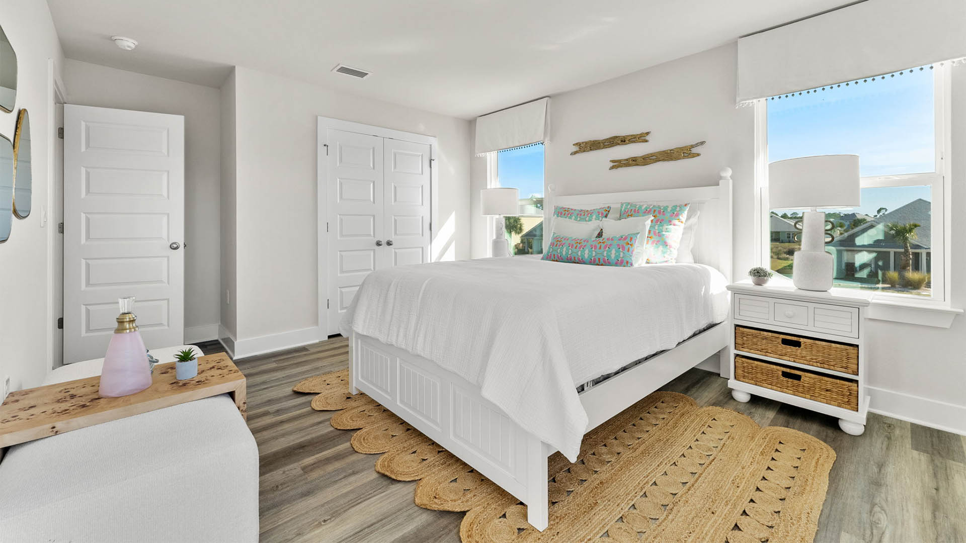 Primary bedroom with EVP flooring with ceiling fan and window and bathroom entrance.