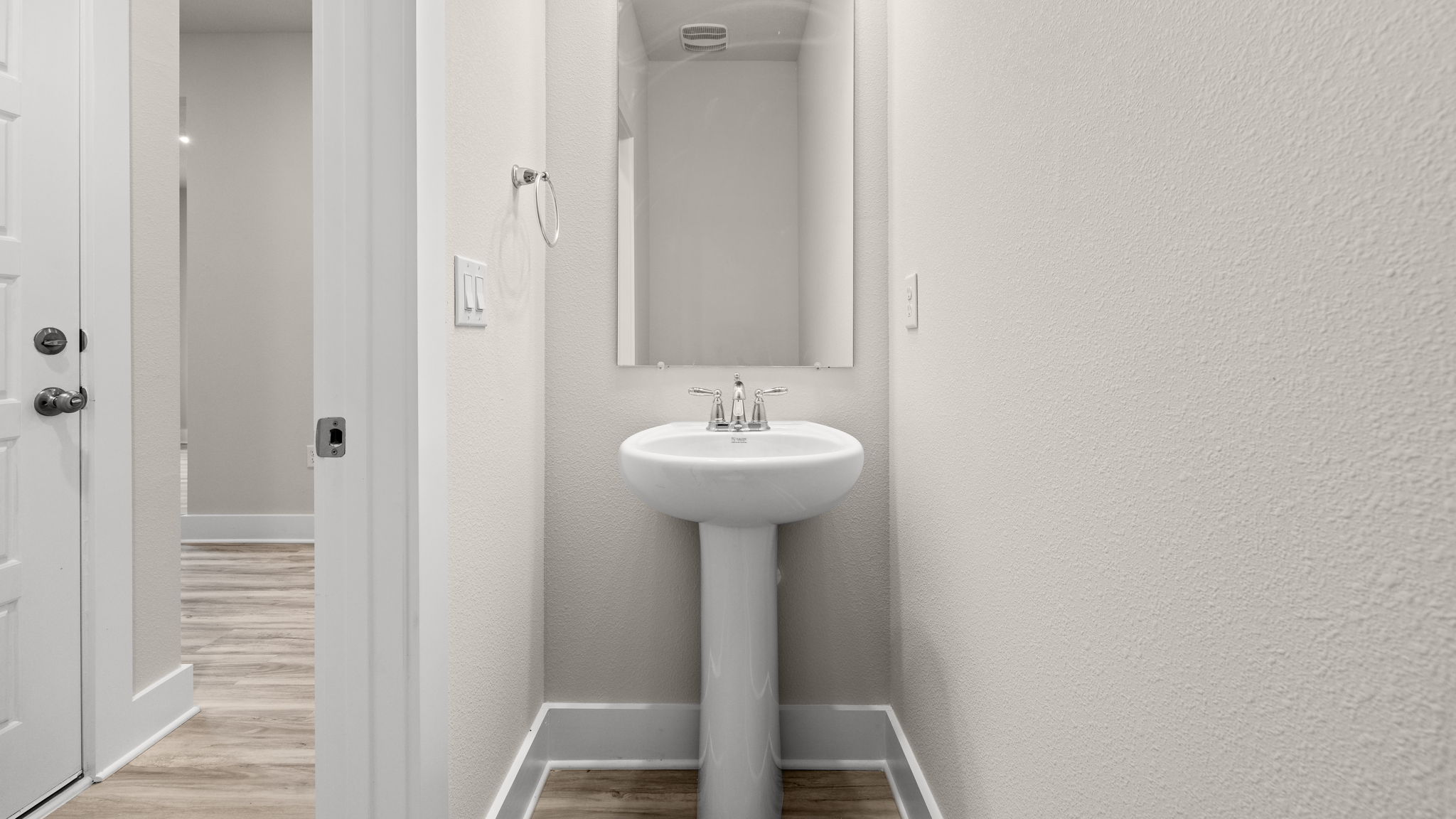 Half bathroom with sink and mirror.