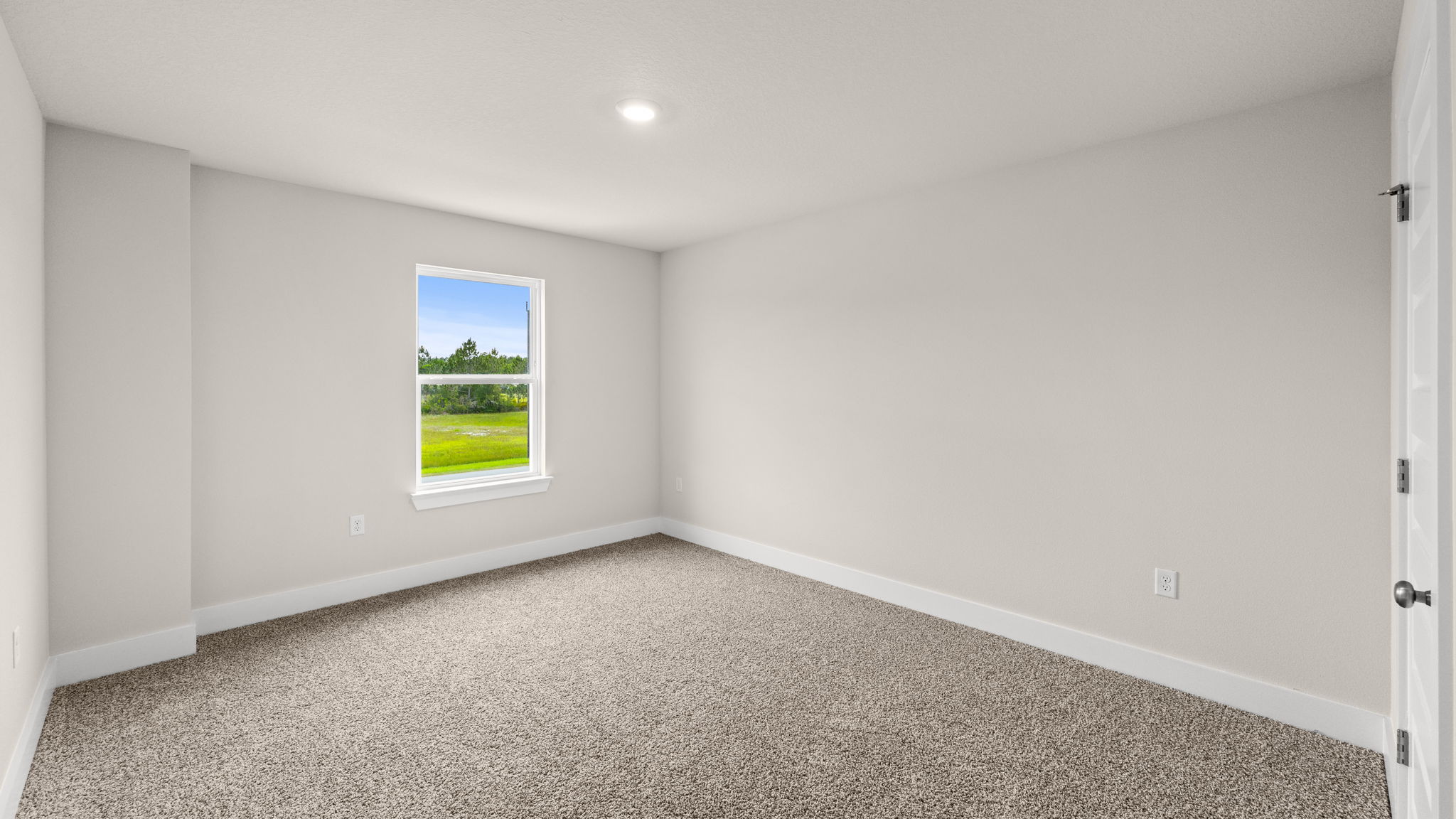 Bedroom with carpet flooring and window.
