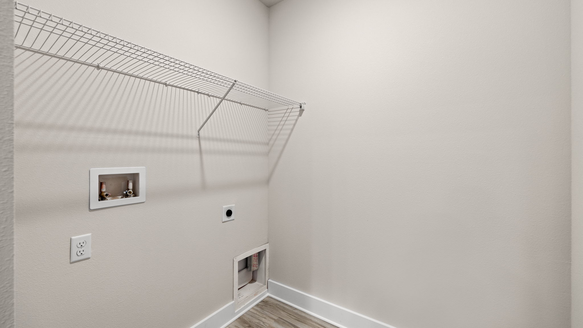 Laundry room with EVP flooring and shelving.