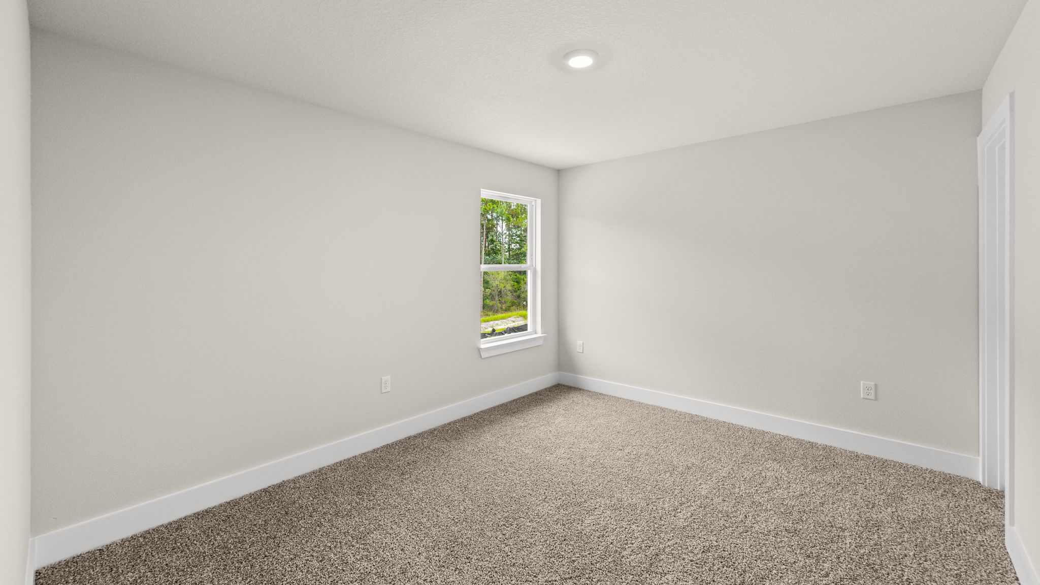 Bedroom with carpet flooring and window.