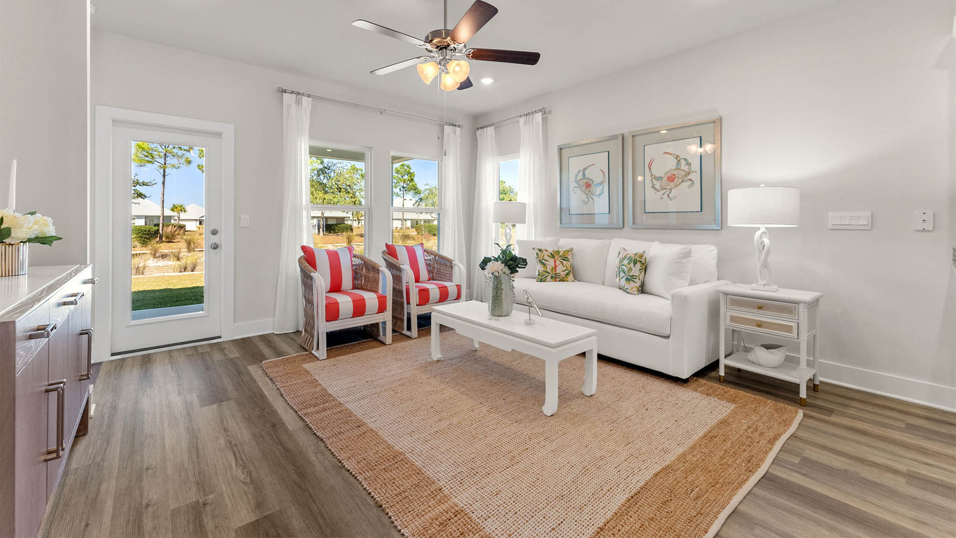 Living room with ceiling fan and EVP flooring and back door.