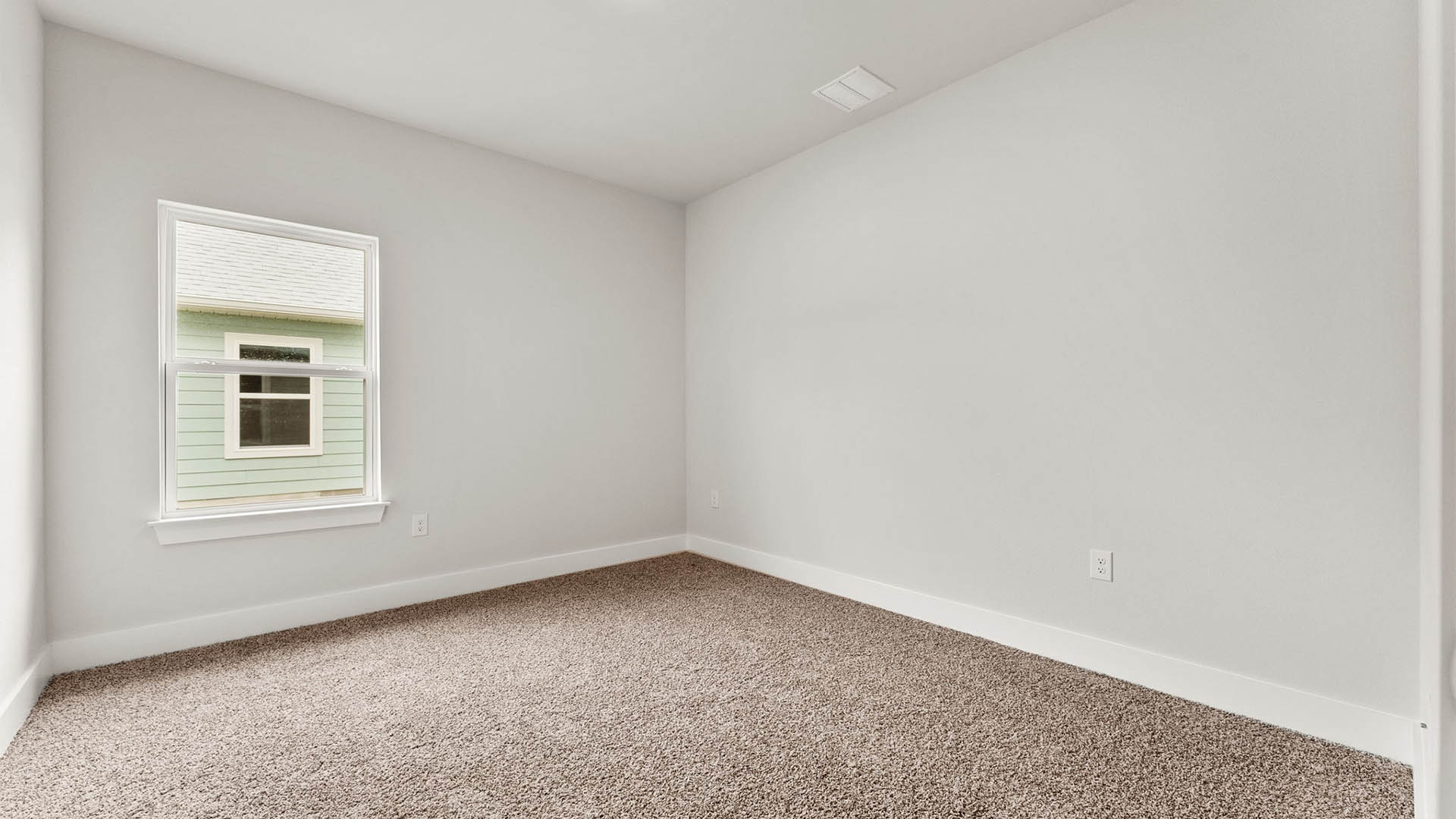Bedroom with carpet floors and window.
