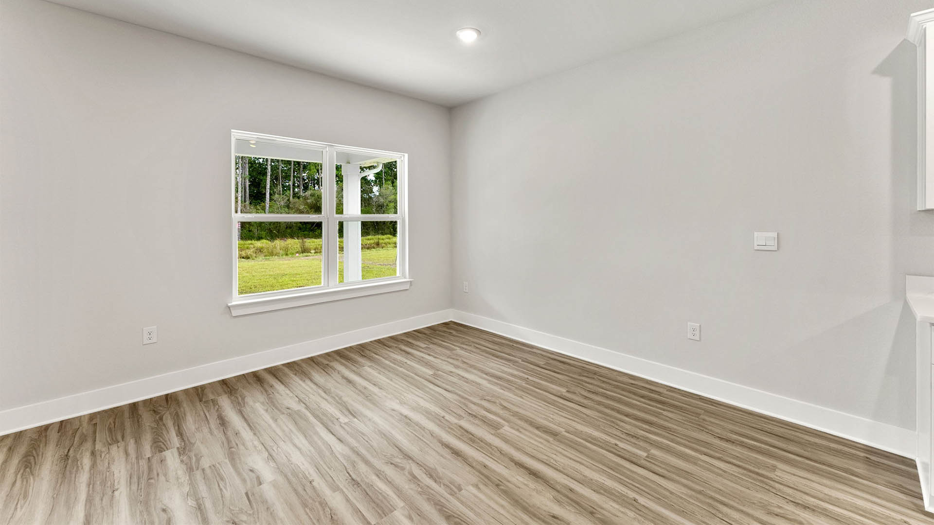 Dining area next to kitchen with EVP floors and windows.