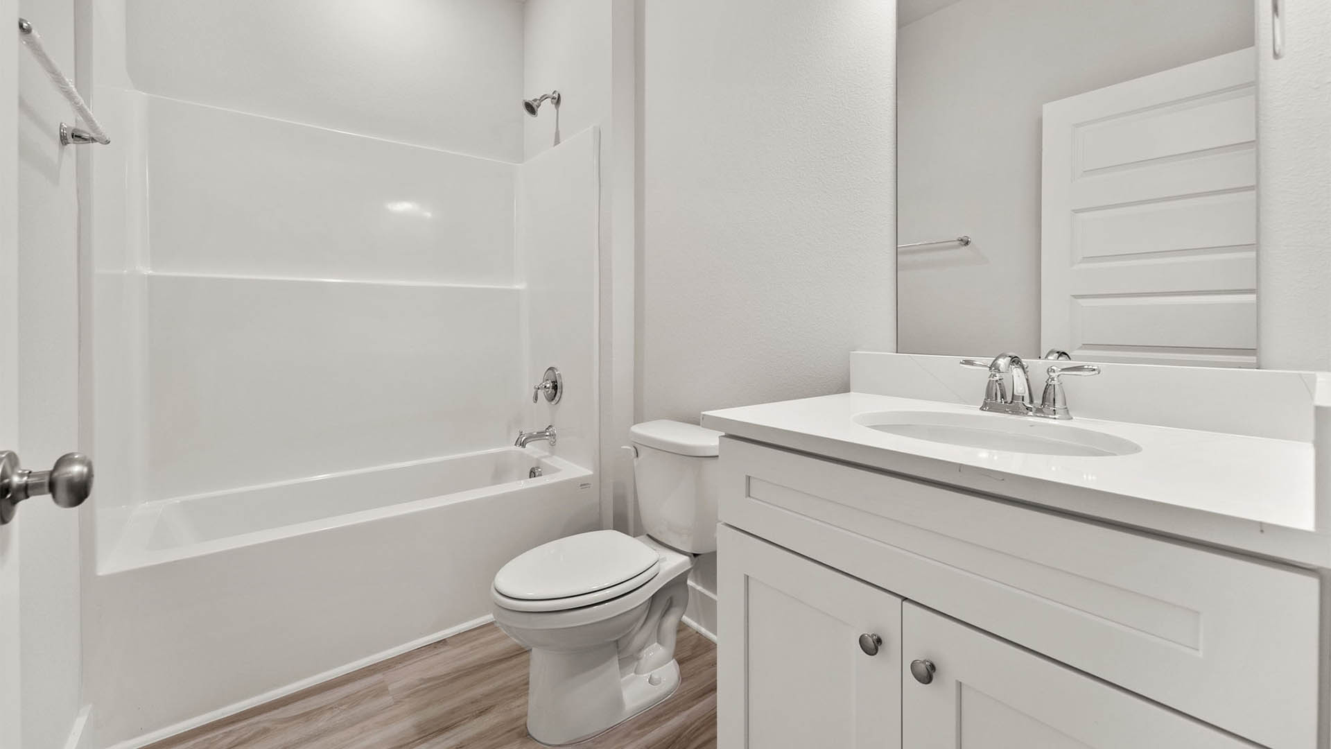 Bathroom with white cabinets and shower and quartz countertops.