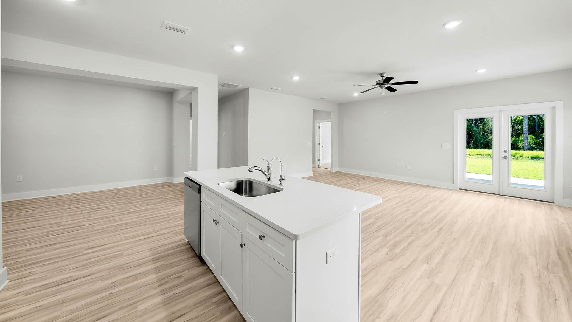 Kitchen island with dishwasher and quartz countertops and living room view.