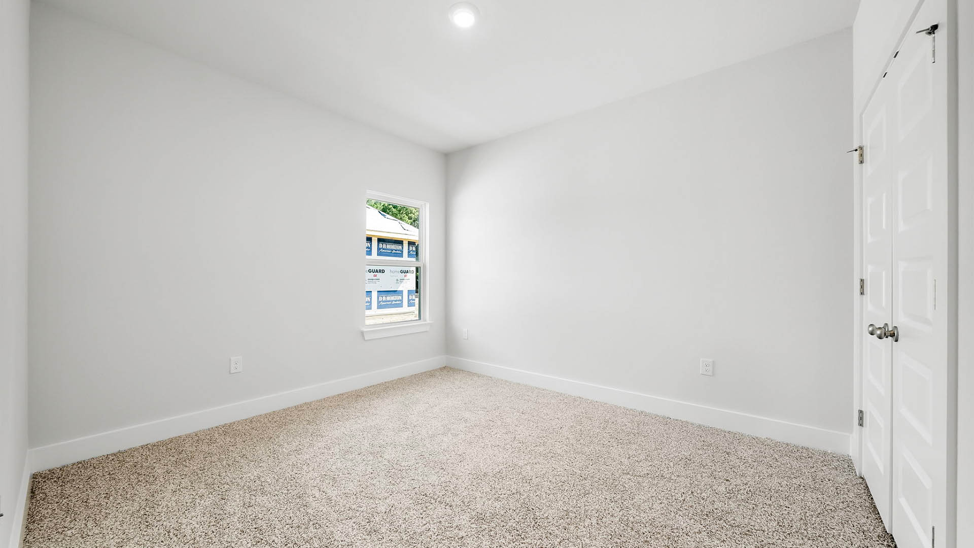 Bedroom with carpet flooring and window.