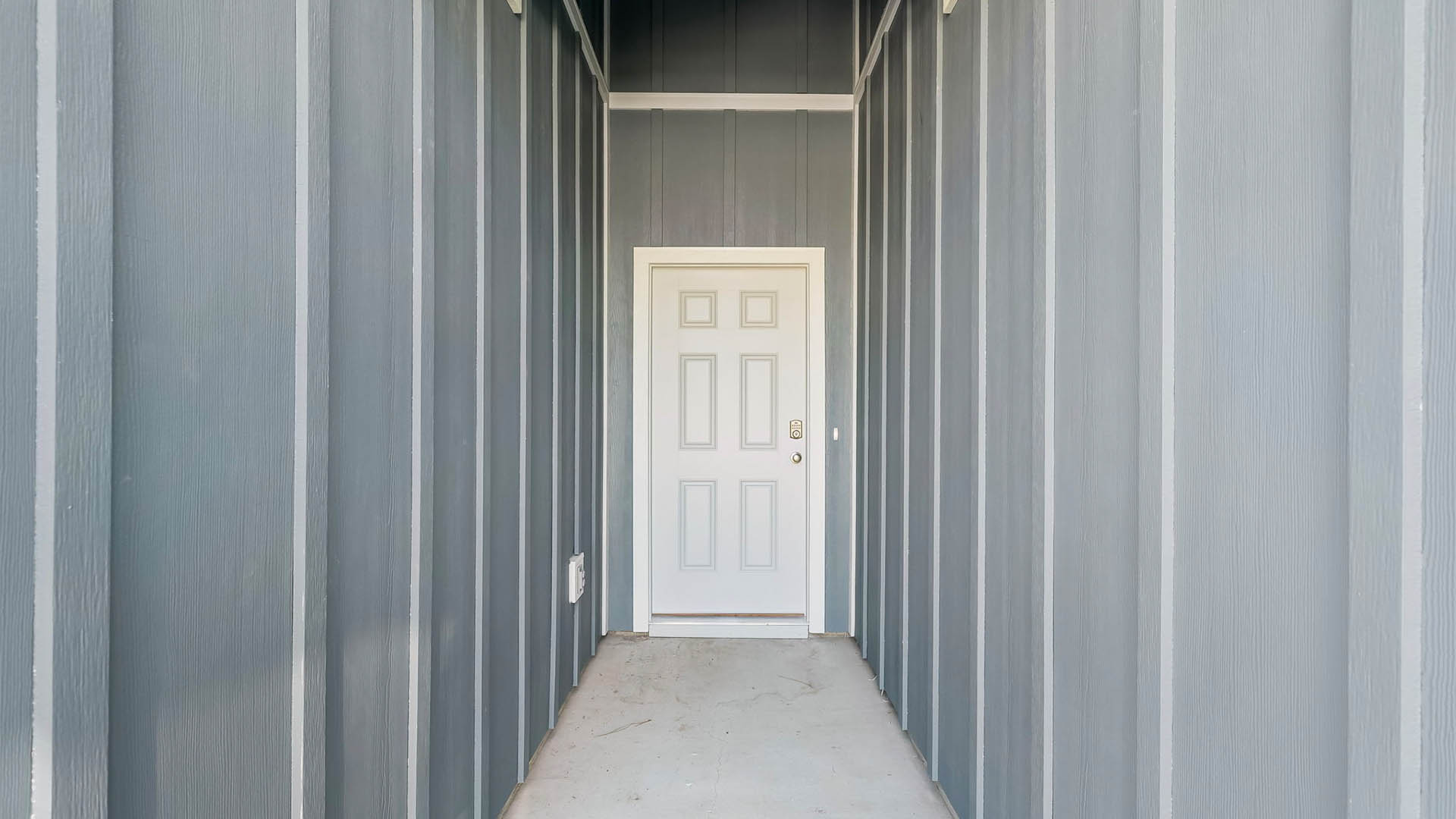 Covered front entrance with white front door.
