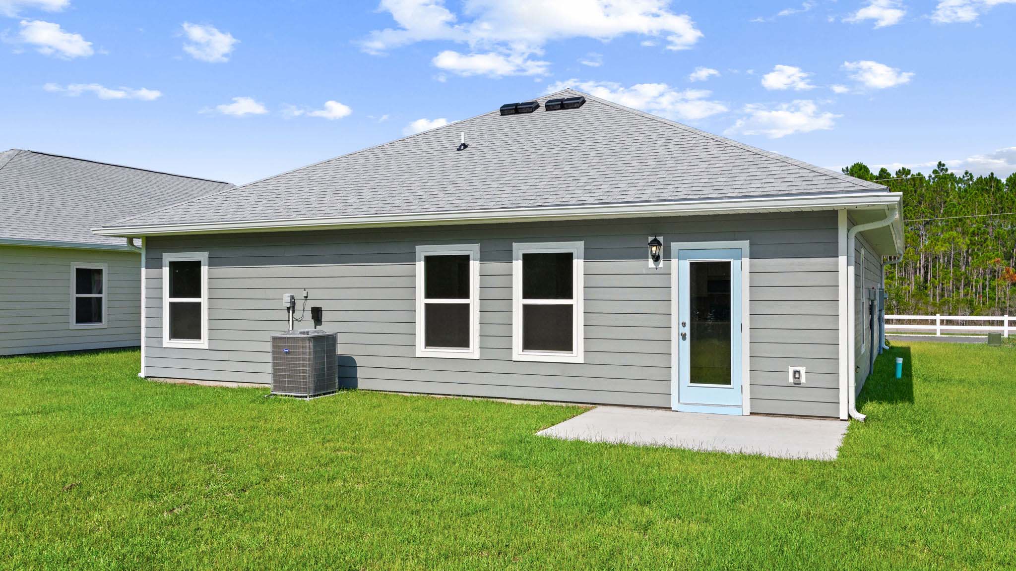 Walker plan rear of home with concrete pad and back yard.