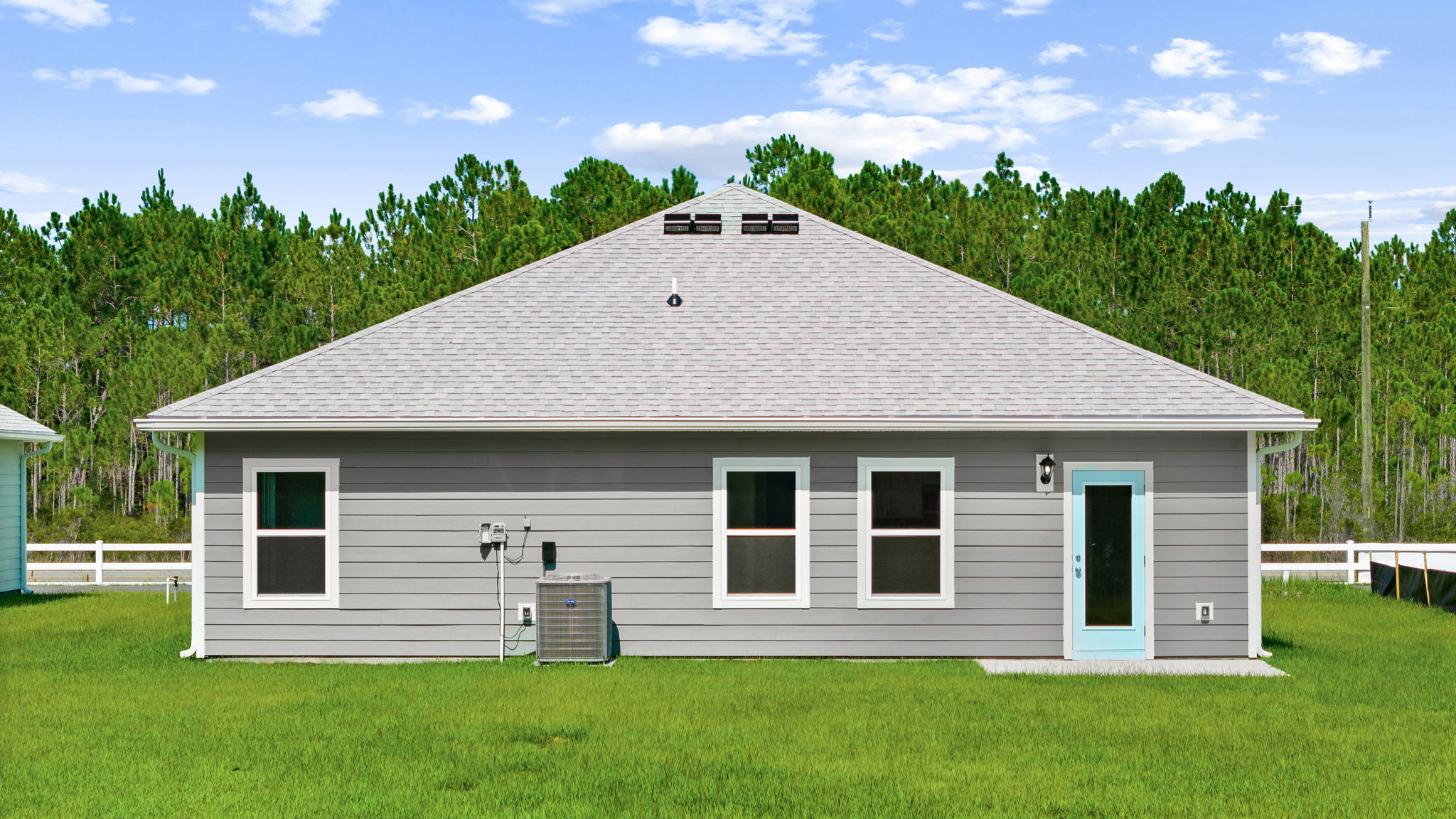 Walker plan rear of home with concrete pad and back yard.