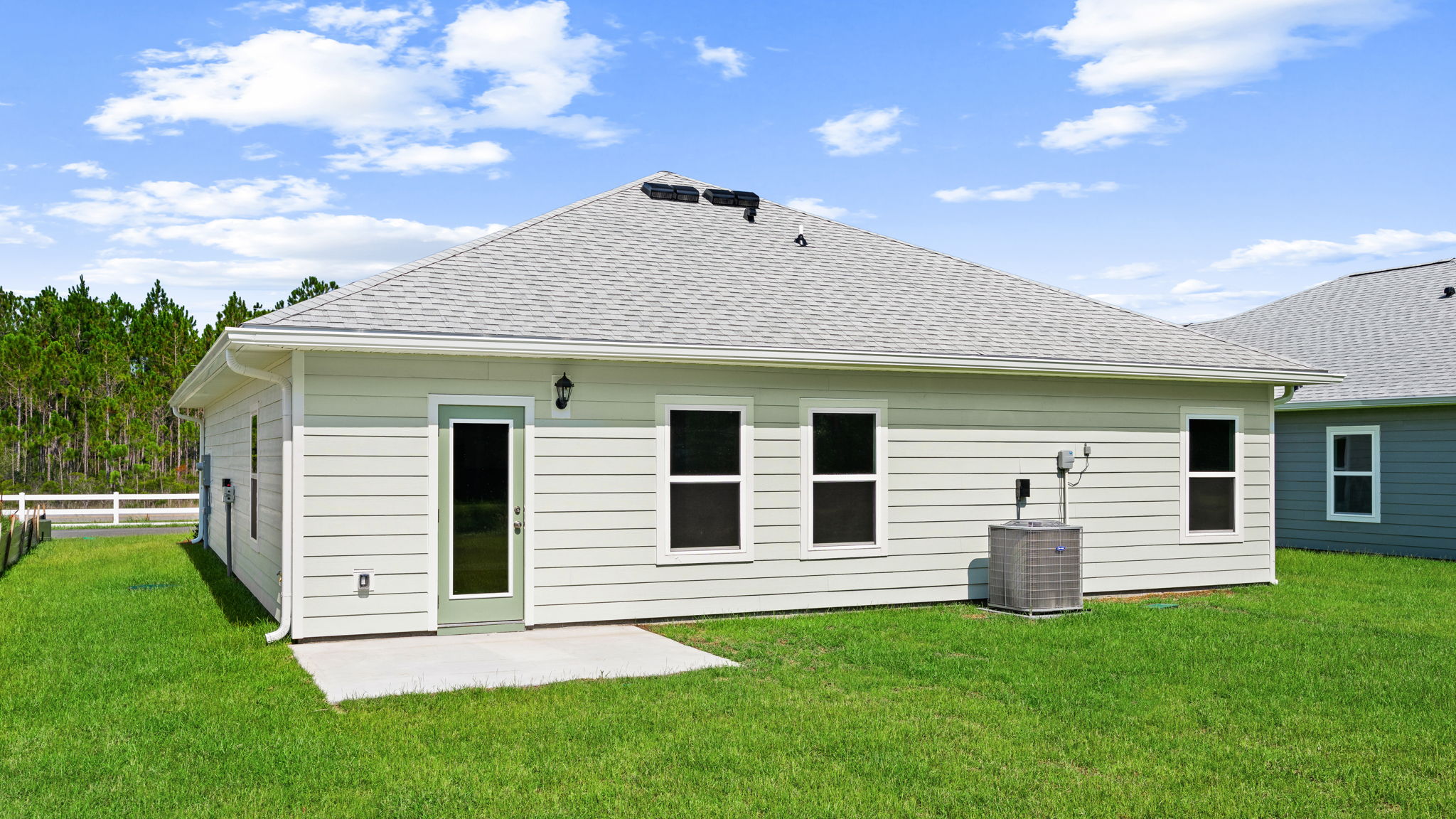 Walker plan rear of home with concrete pad and back yard.