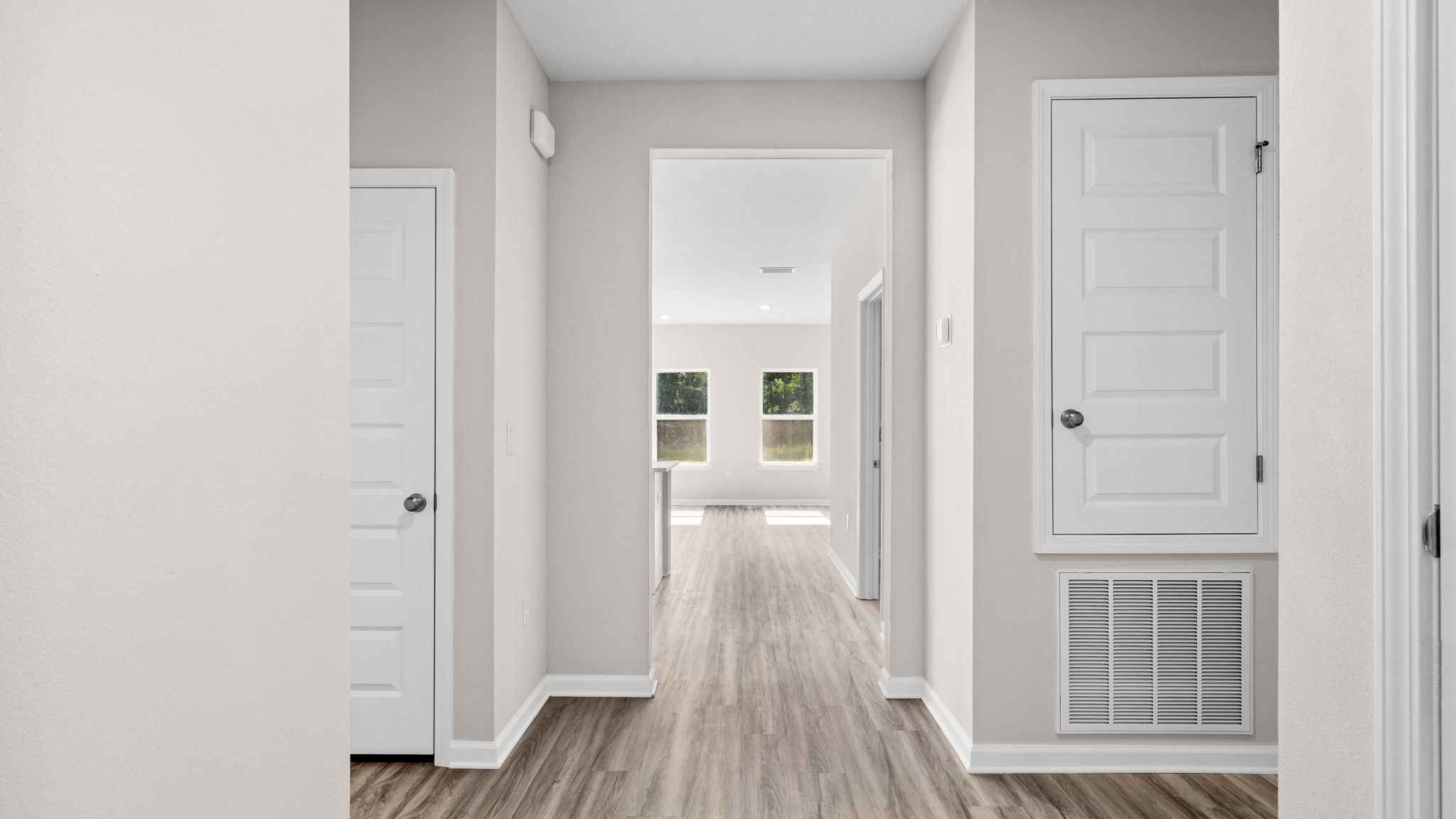 Front entrance hallway with EVP flooring next to garage and bedrooms.