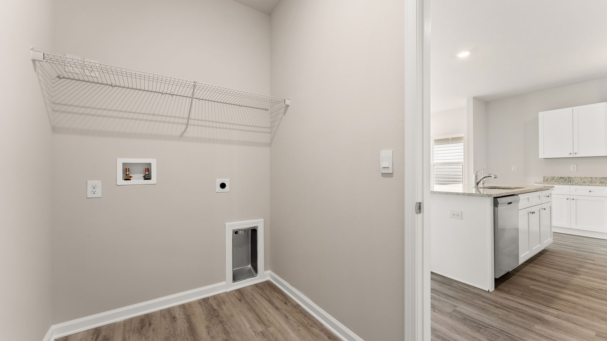 Laundry room in hallway with ventilated shelving.