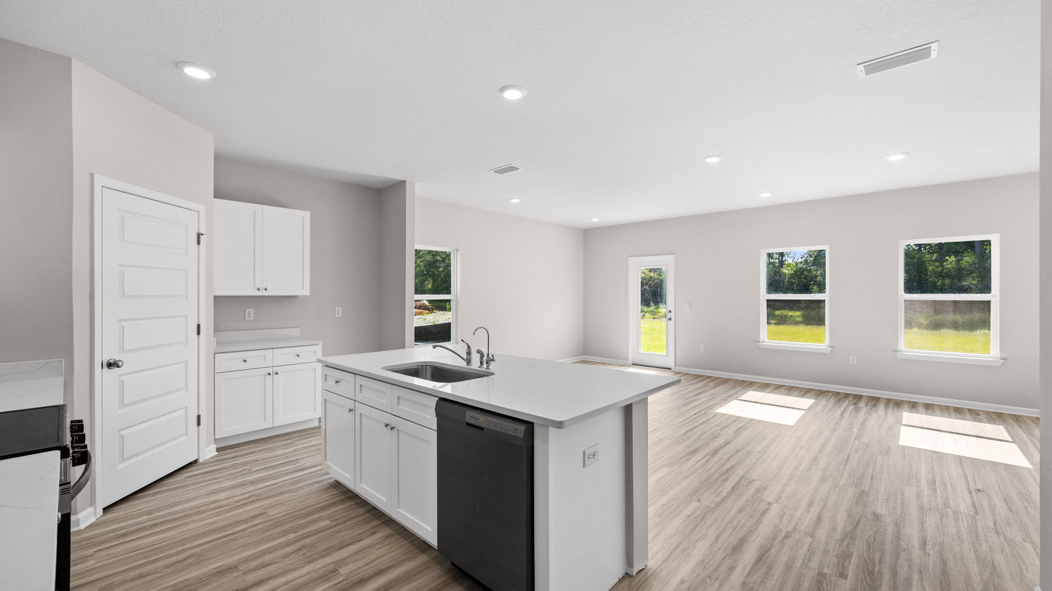 Living room and kitchen view next to hallway.
