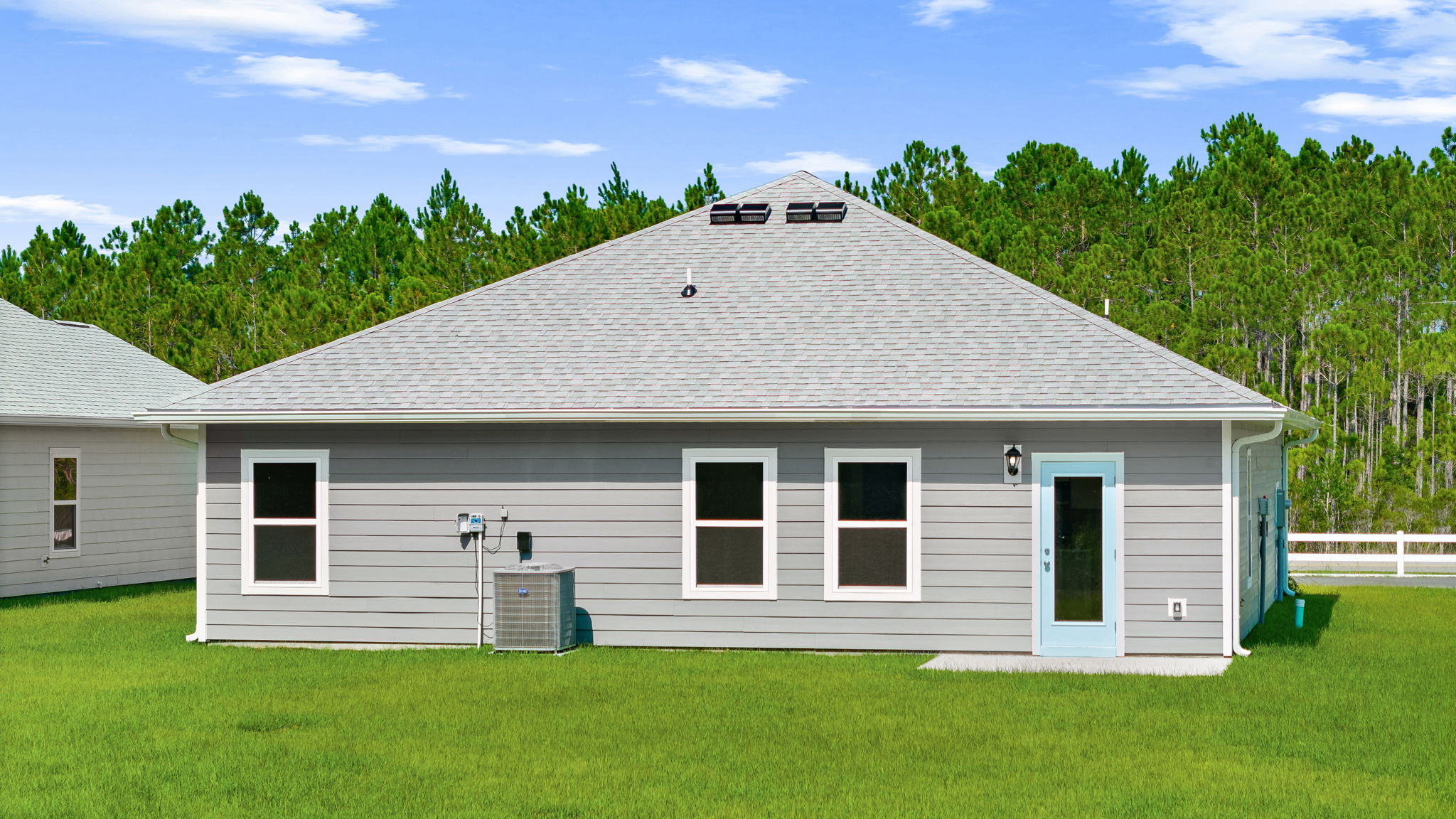 Walker plan rear of home with concrete pad and back yard.
