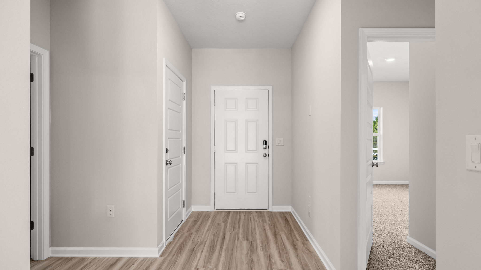 Front entrance hallway with EVP flooring next to garage and bedrooms.