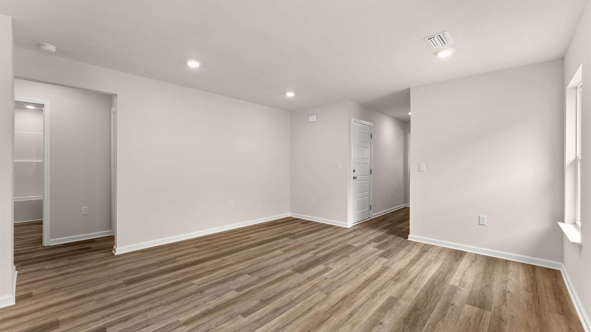 Open living room and kitchen with EVP flooring and hallway.