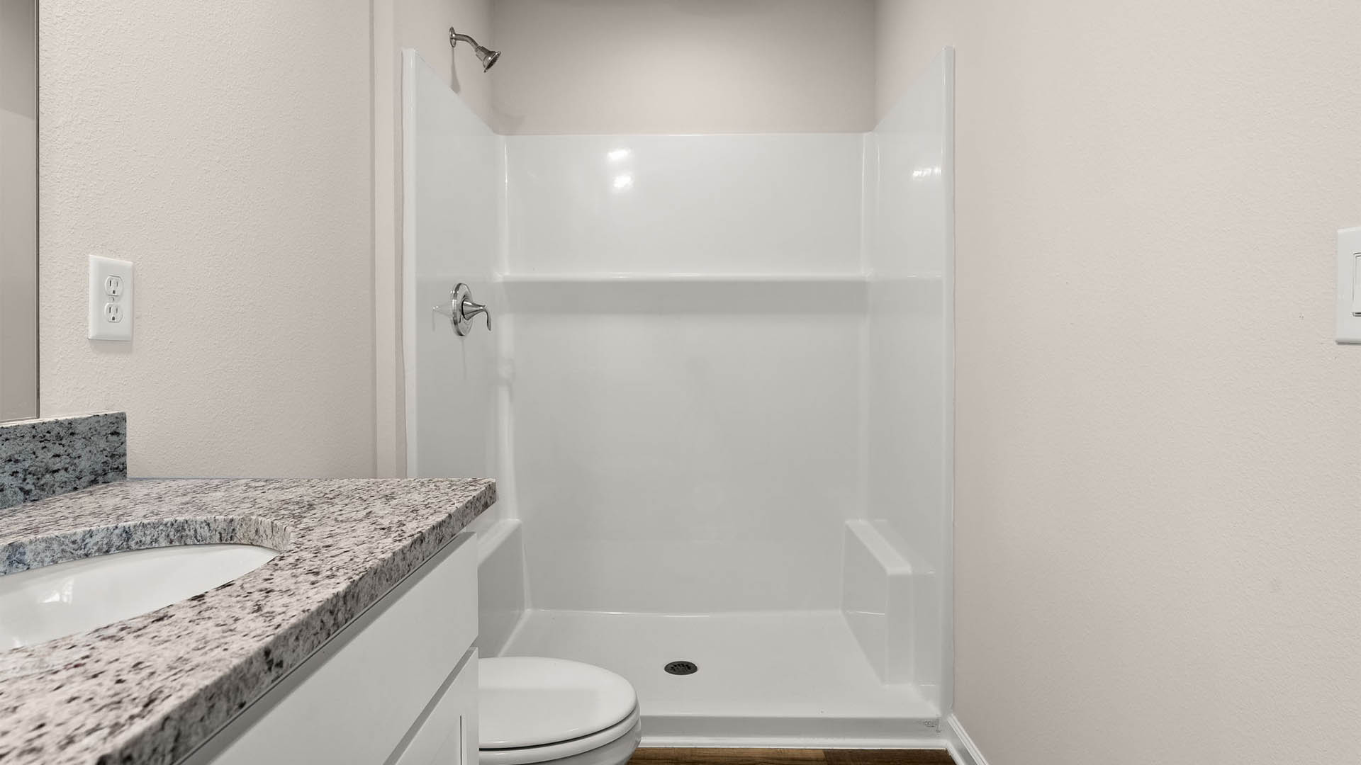 Primary bathroom with double vanity granite countertops and toilet and shower and EVP flooring.