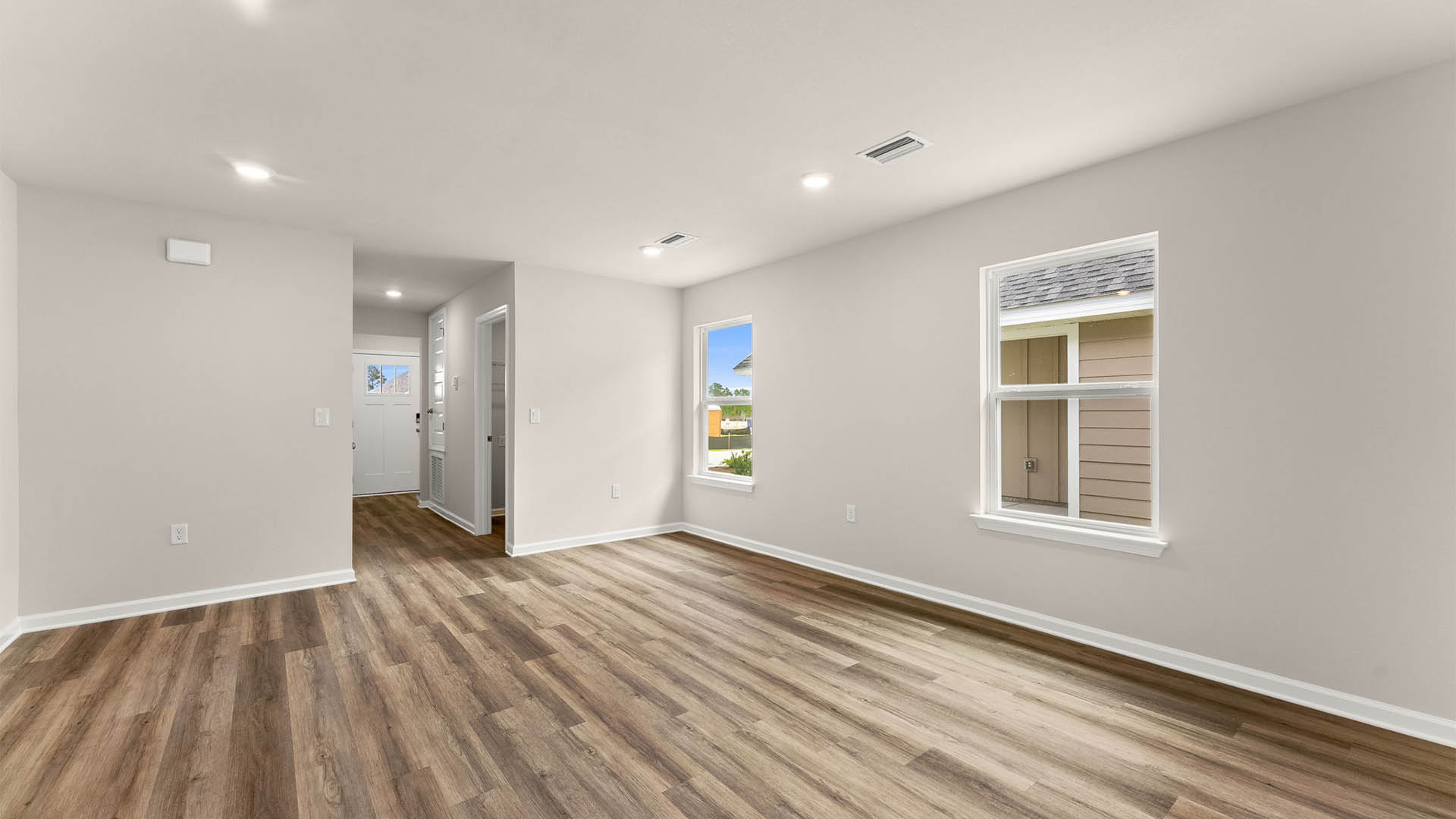 Open living room and kitchen with EVP flooring and hallway.