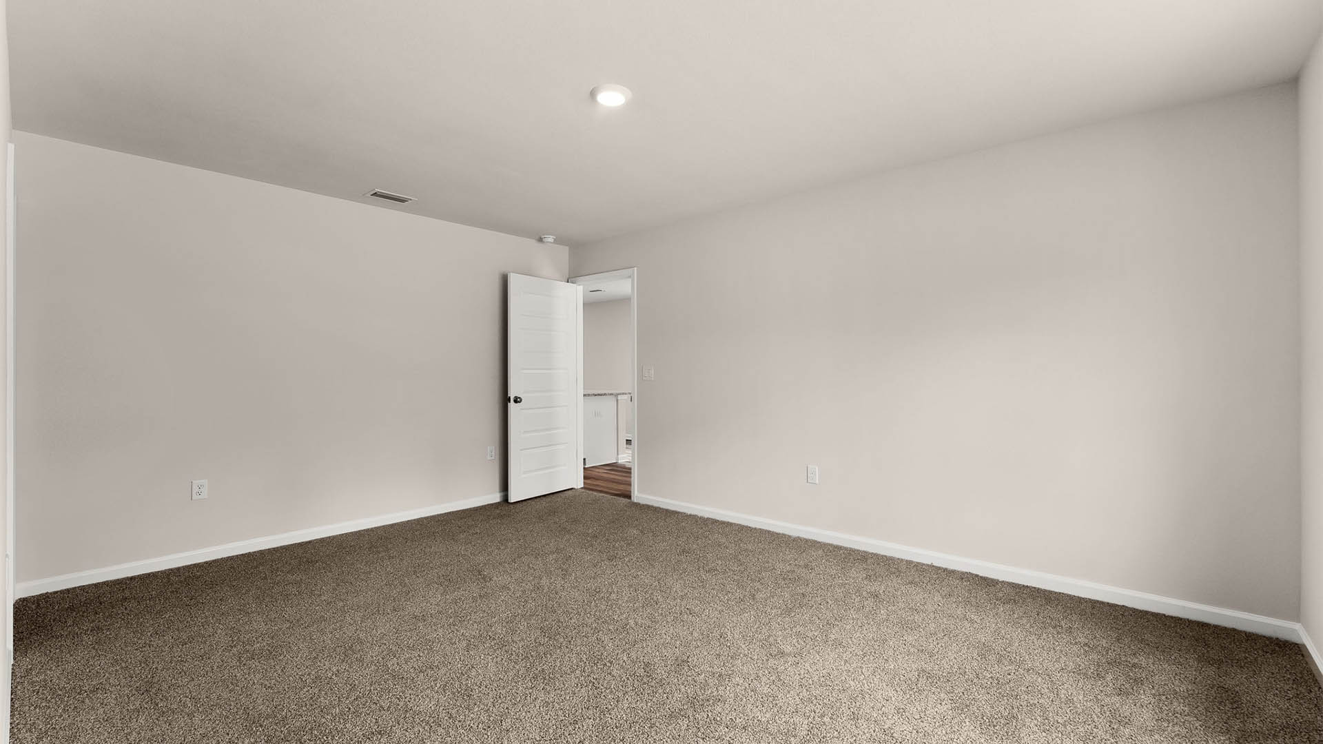 Primary bedroom with carpet flooring.
