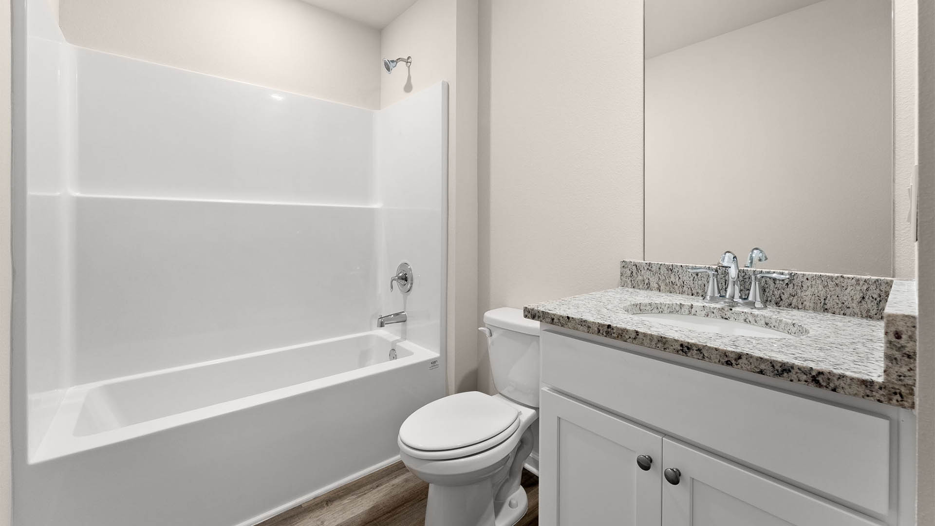 Bathroom with single vanity granite countertops and tub and shower combo and toilet.