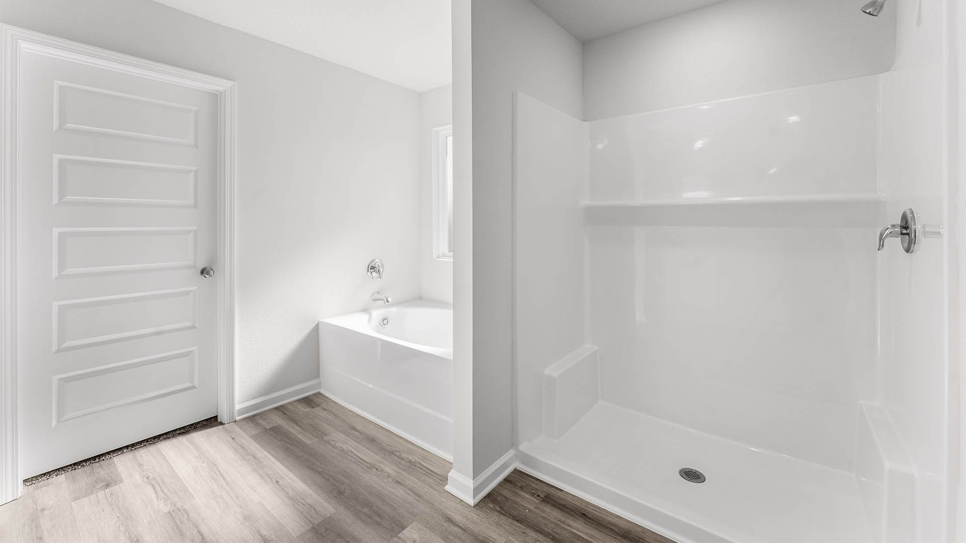 Primary bathroom with separate shower and tub with coated window.