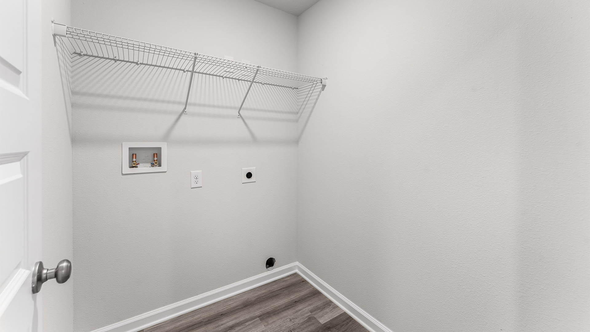 Upstairs laundry room with EVP flooring and ventilated shelving.