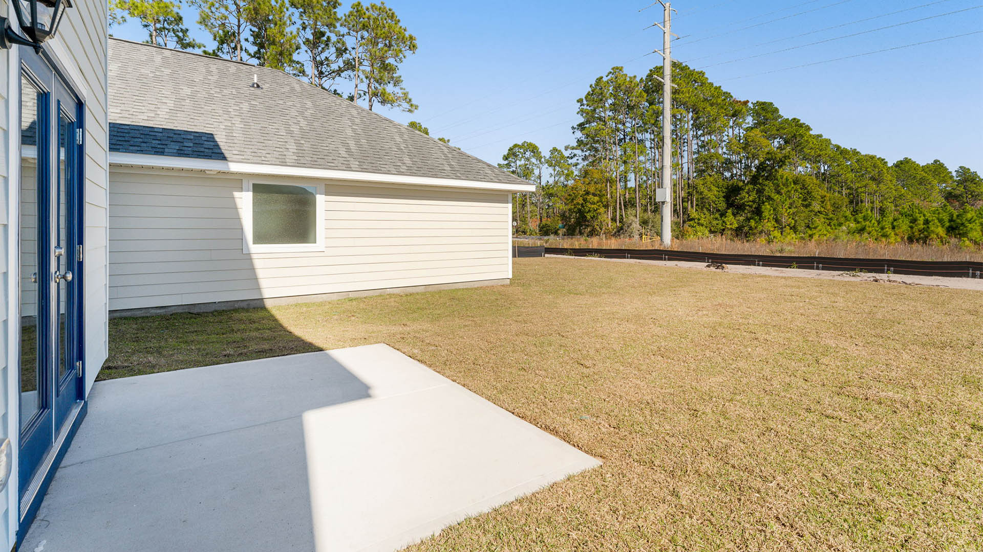 Back yard view and concrete pad on rear of home.