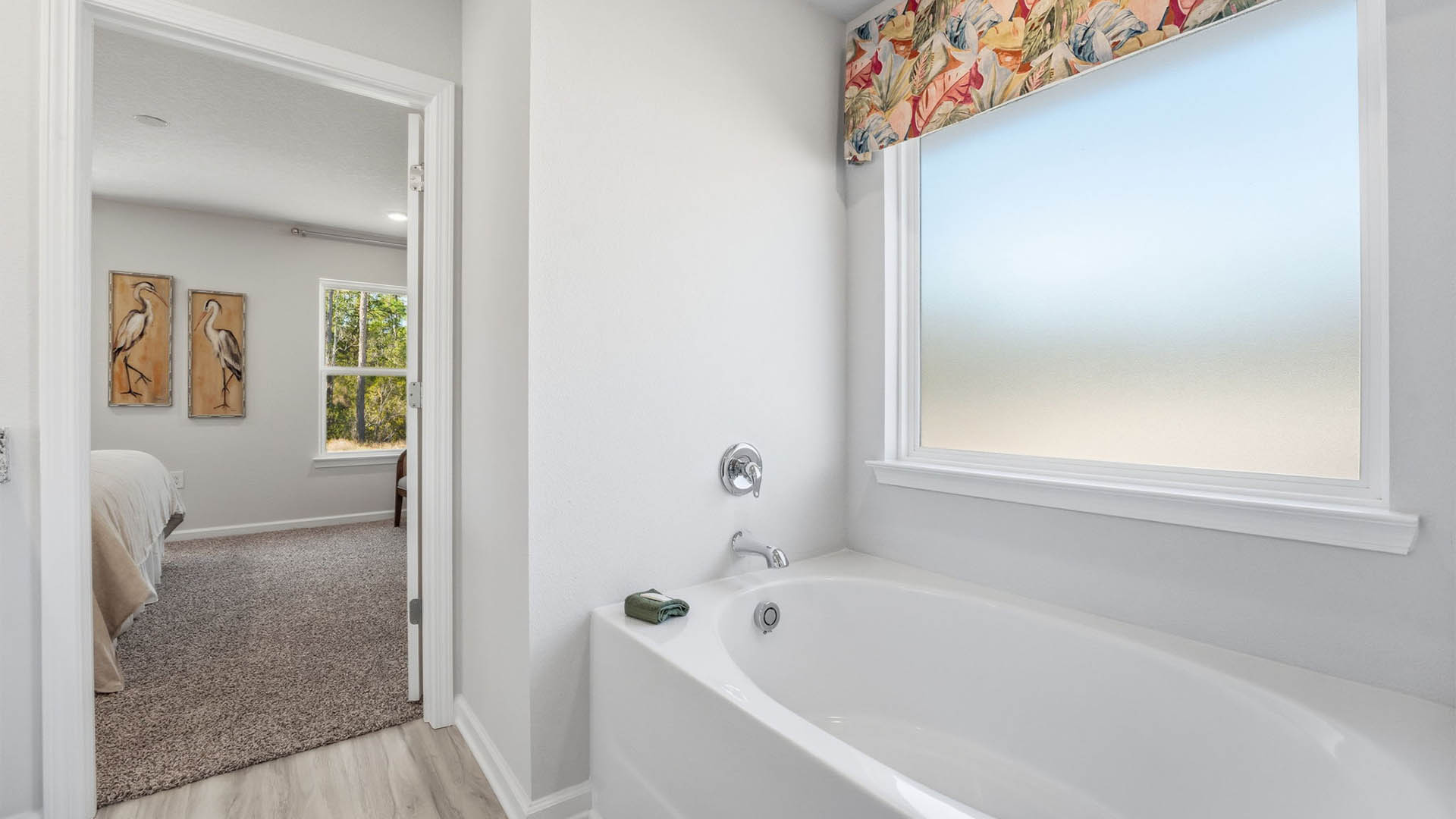 Primary bathroom tub and frosted mirror.