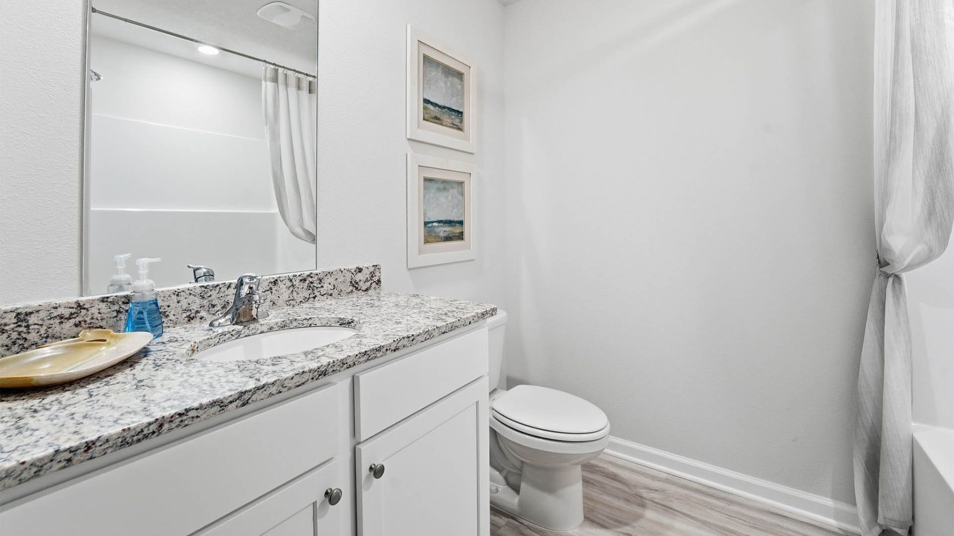 Bathroom with single vanity sink and granite countertop and toilet and shower tub combo.