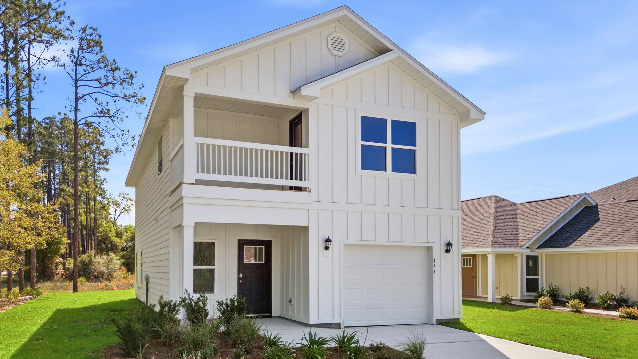 Monroe plan with Hardie siding and single-car garage and second floor balcony and covered front patio.