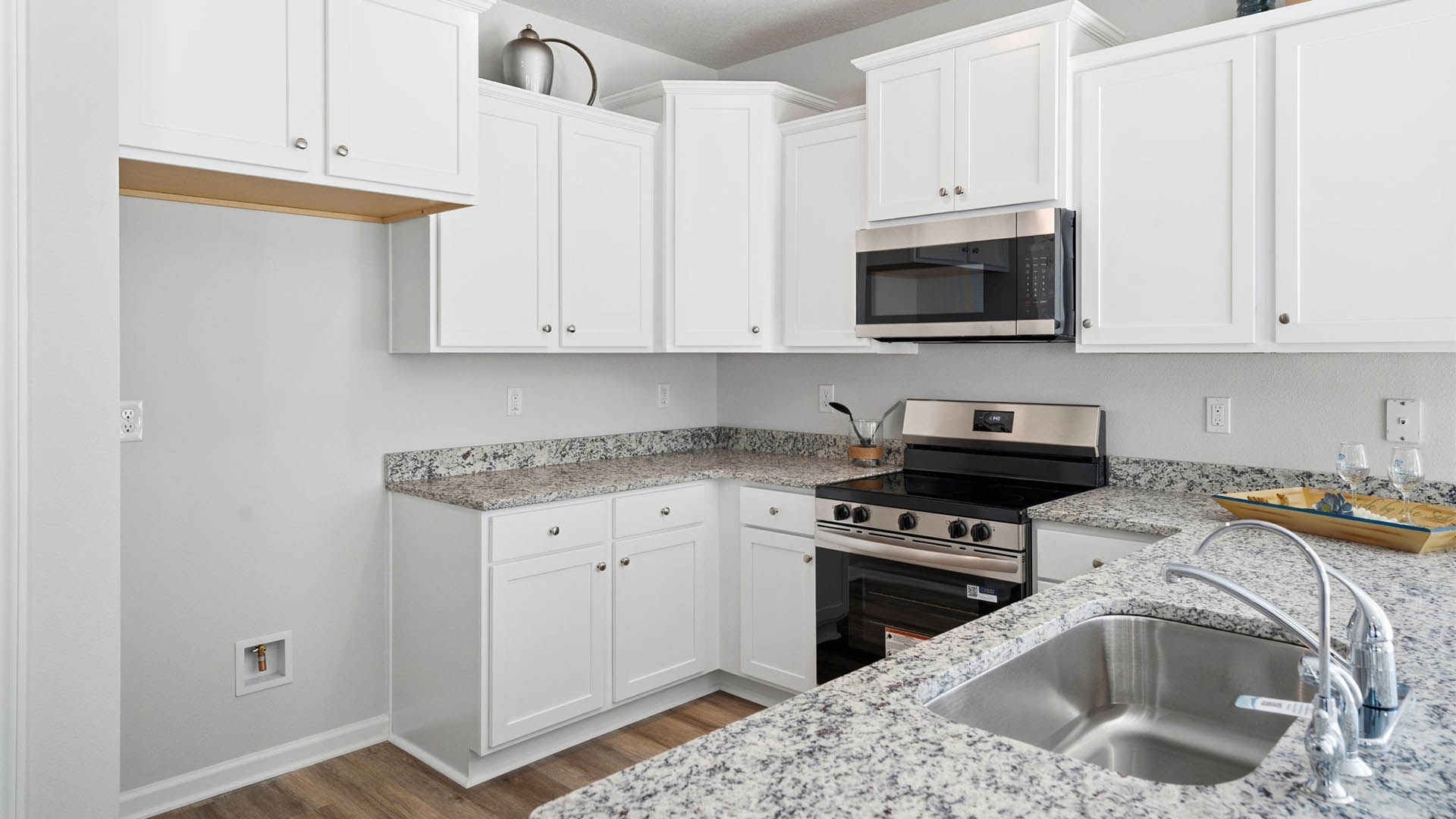 Kitchen with white cabinets and granite countertops and stainless-steel appliances and peninsula bar.