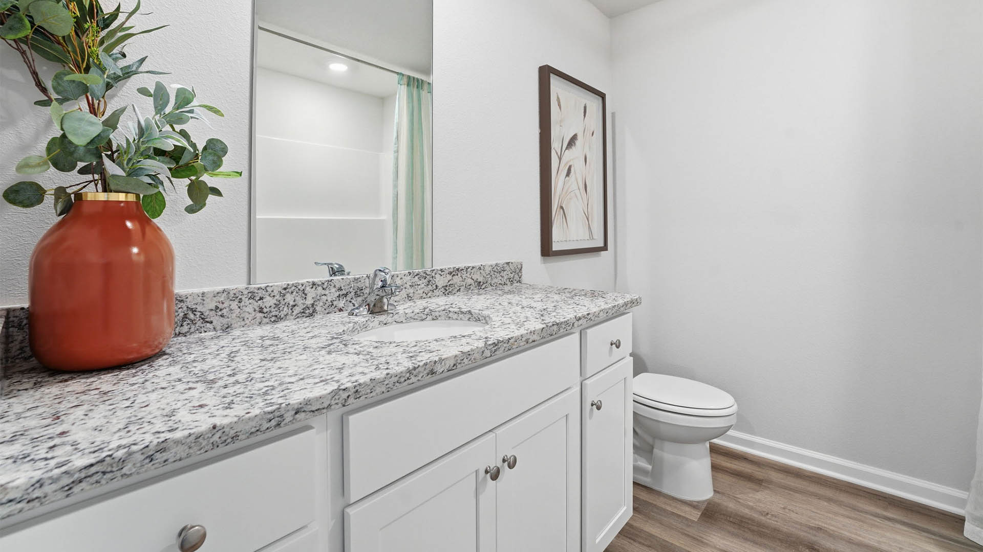 Bathroom with single vanity sink with granite countertops and toilet and EVP flooring.