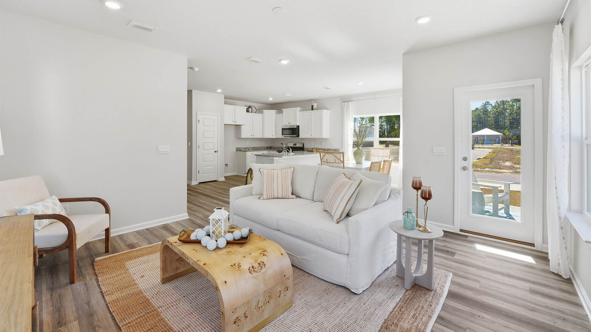 Living room with EVP flooring looking into kitchen next to back door.
