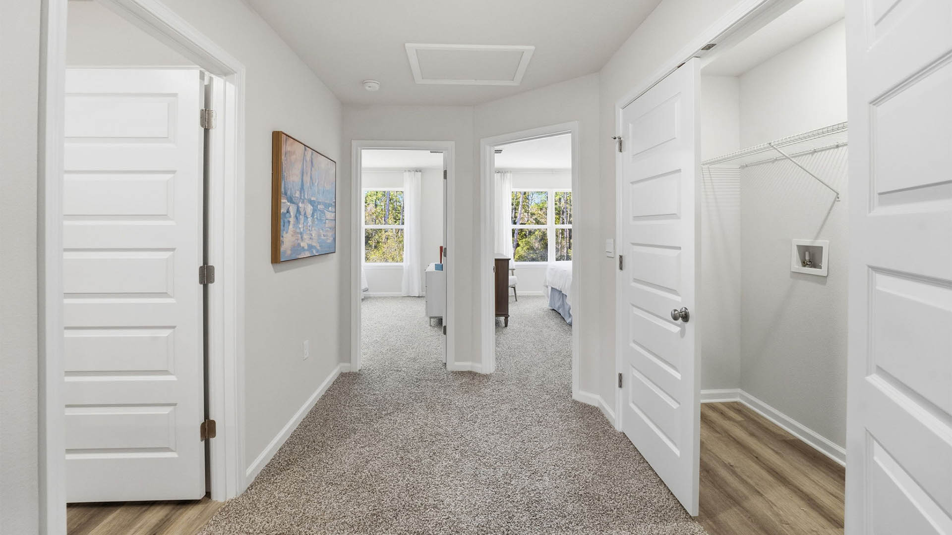 Upstairs hallway with laundry room and bathroom and bedrooms.
