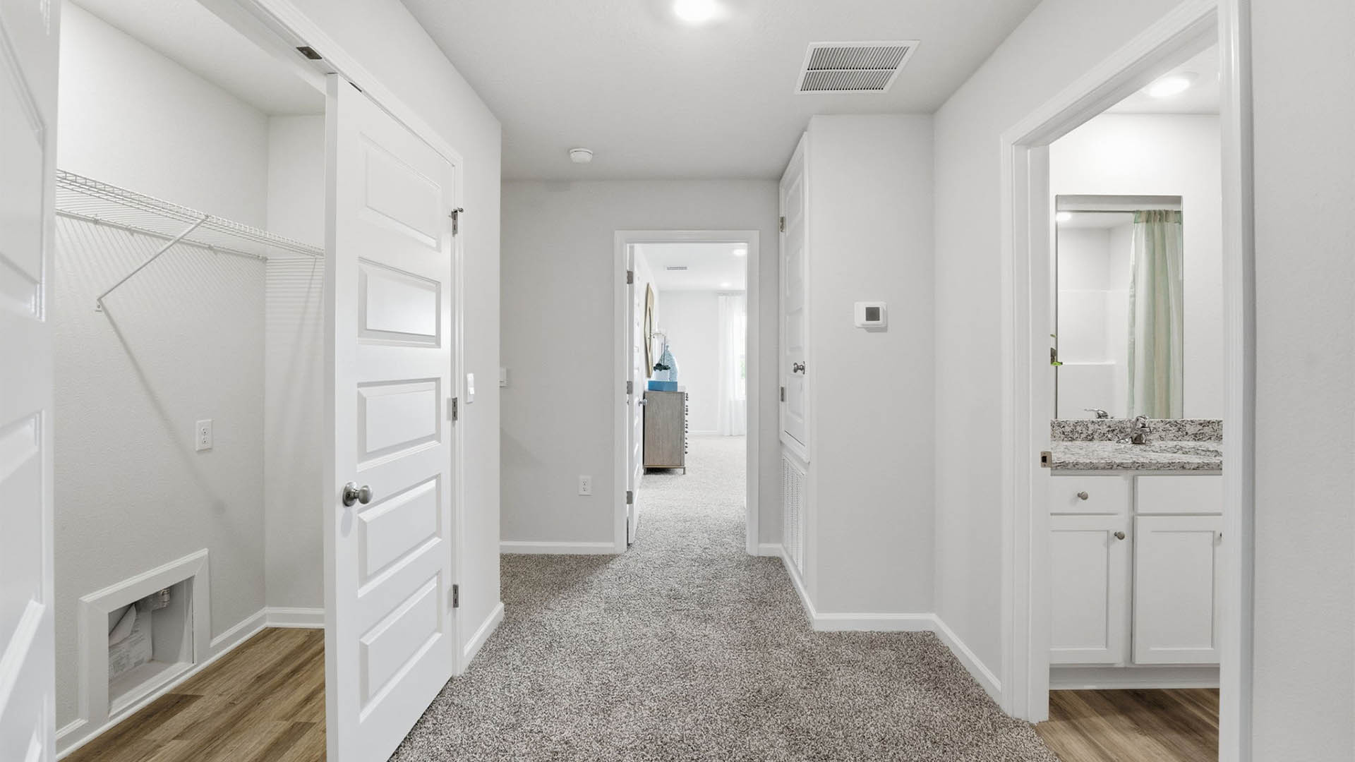 Upstairs hallway with laundry room and bathroom and bedrooms.