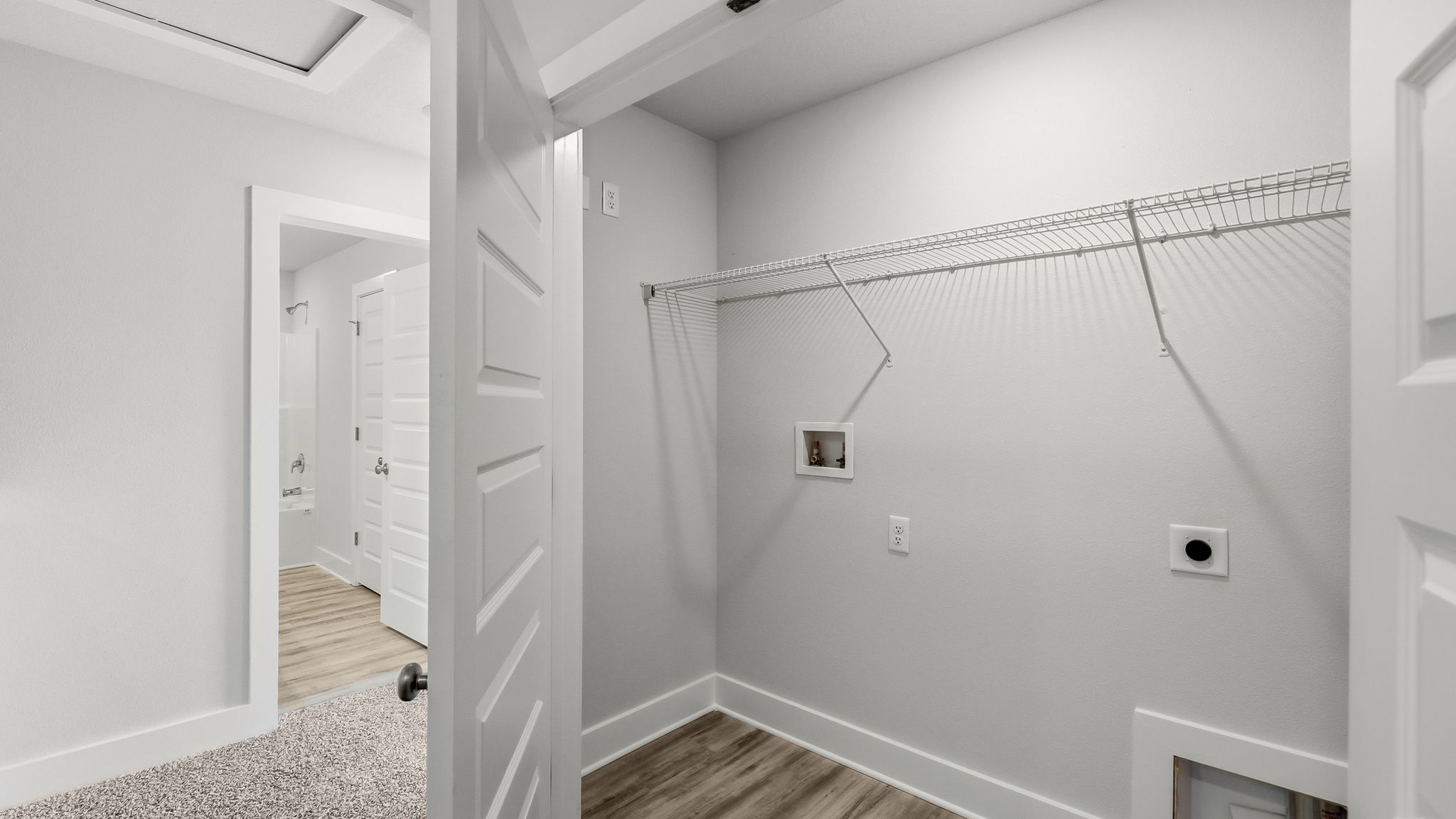 Upstairs laundry room with shelving and EVP flooring.