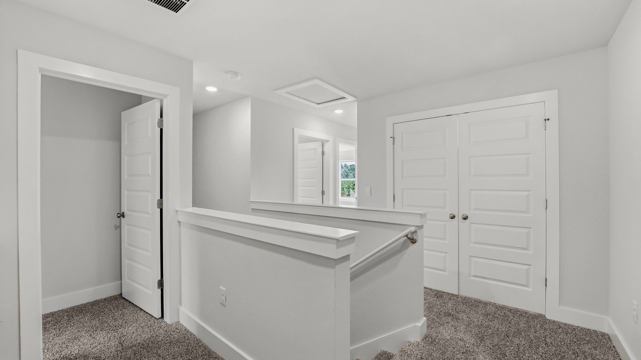 Upstairs foyer with stairs and carpet and bedrooms and laundry room.