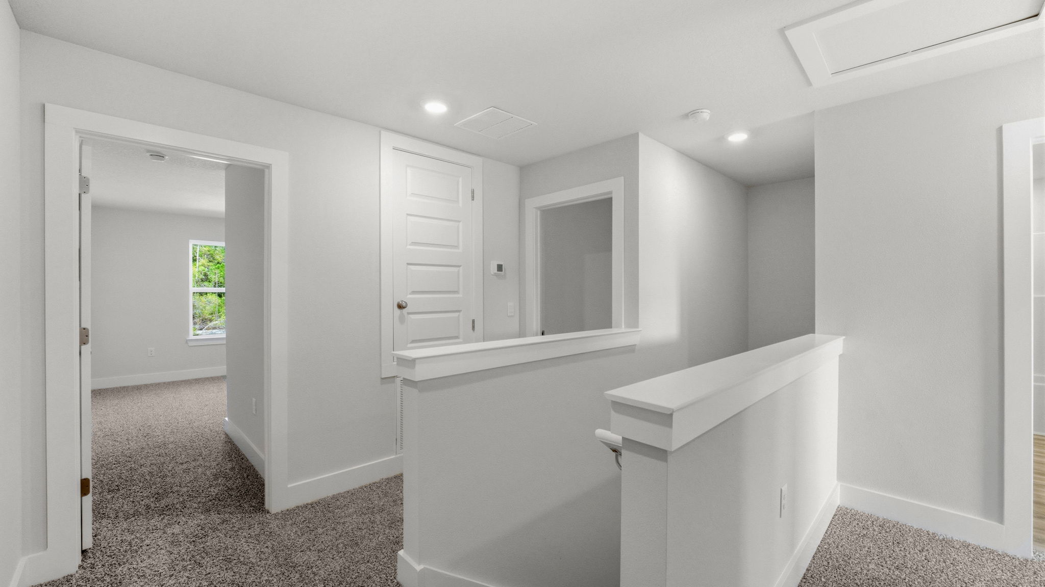 Upstairs foyer with stairs and carpet and bedrooms and laundry room.