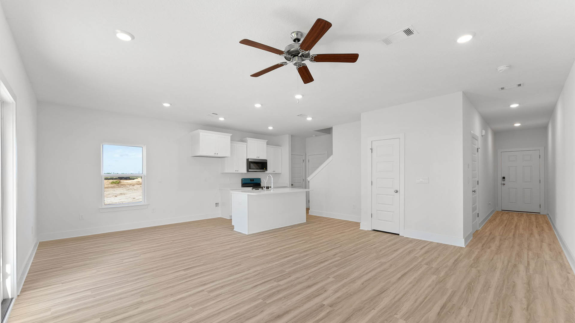 Open kitchen and living room with ceiling fan and EVP flooring.