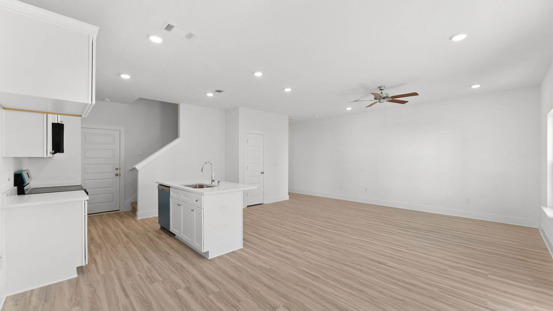 Open kitchen and living room with ceiling fan and EVP flooring.