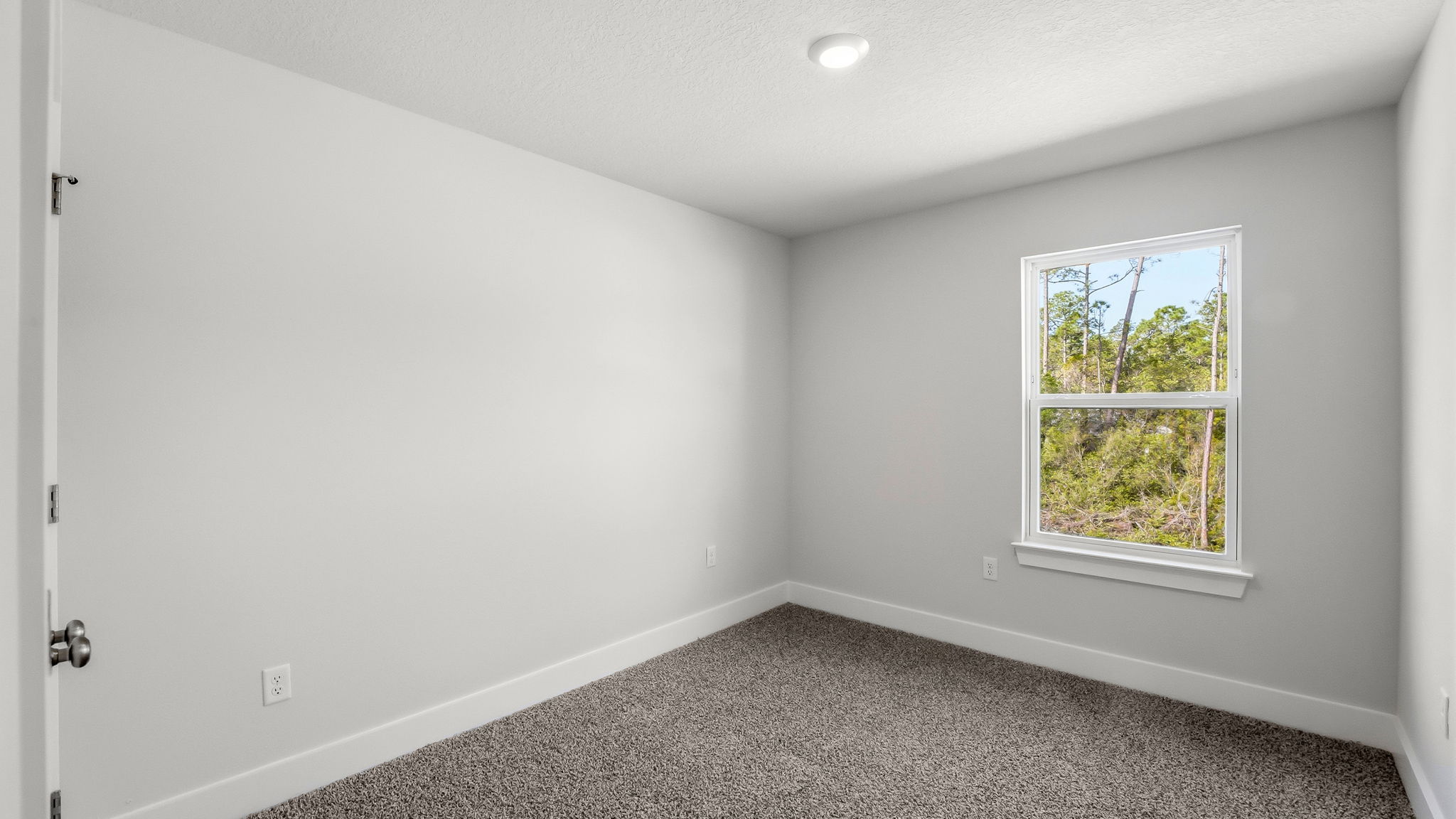 Bedroom with carpet flooring and closet and window.