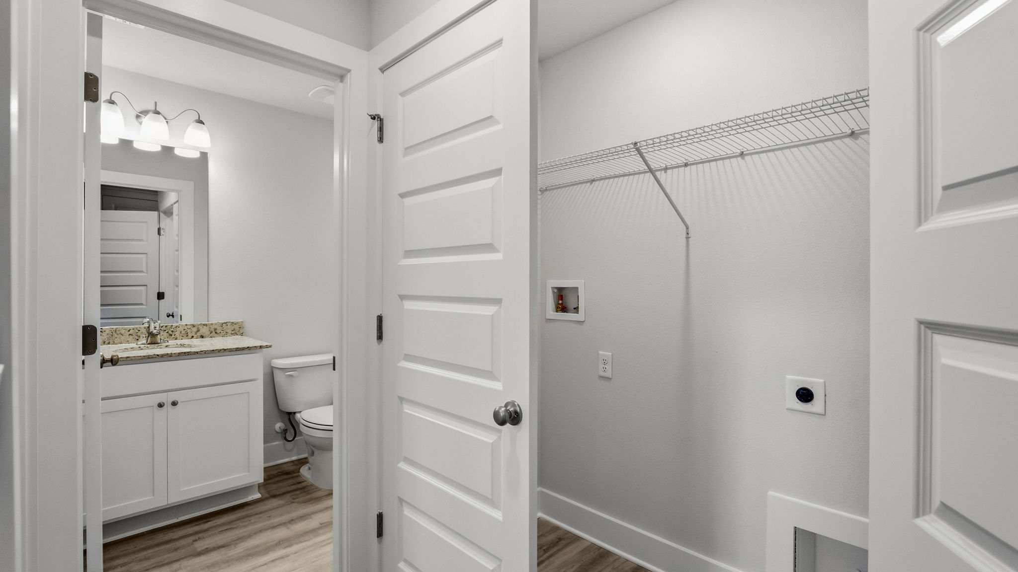 Upstairs laundry room with shelving and EVP flooring.