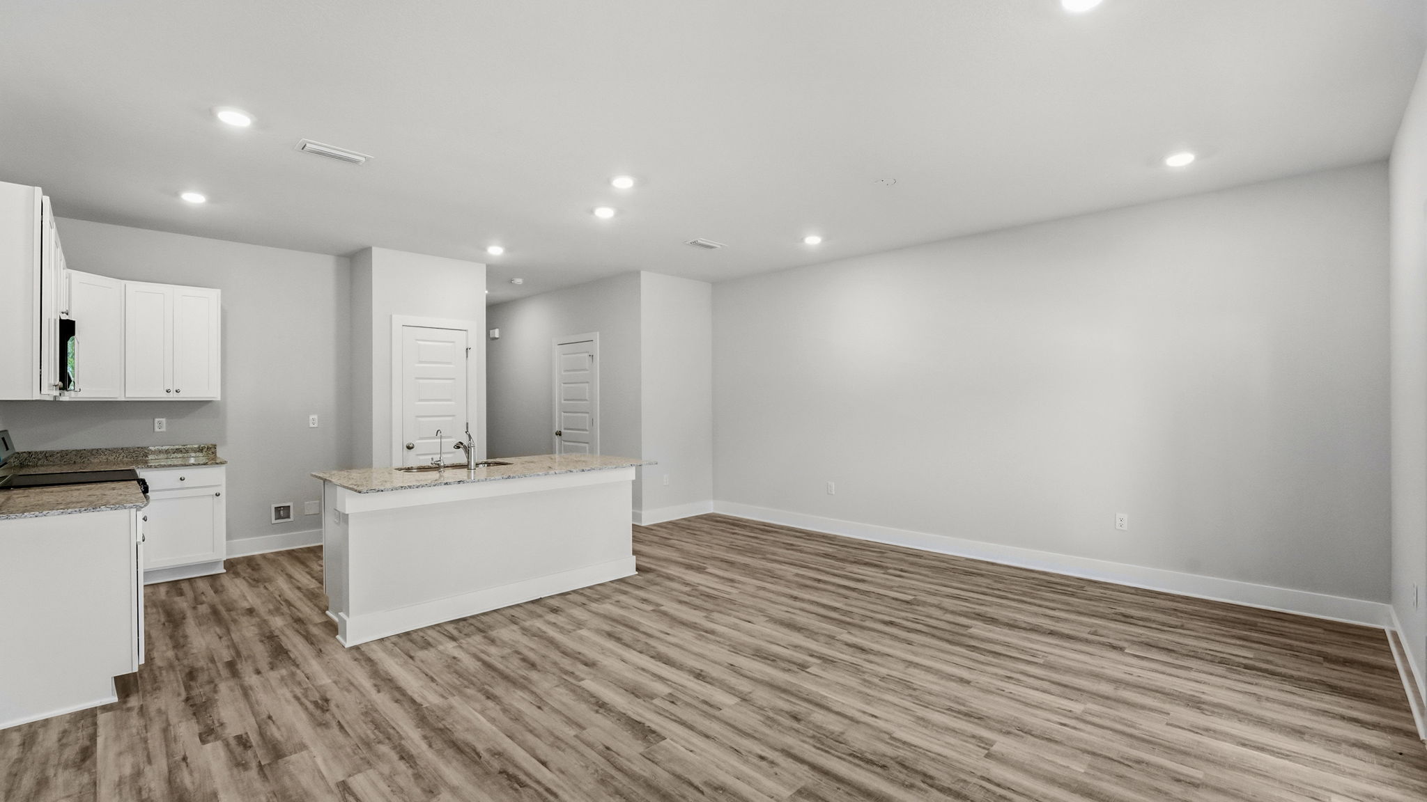 Open living room with EVP flooring and kitchen.