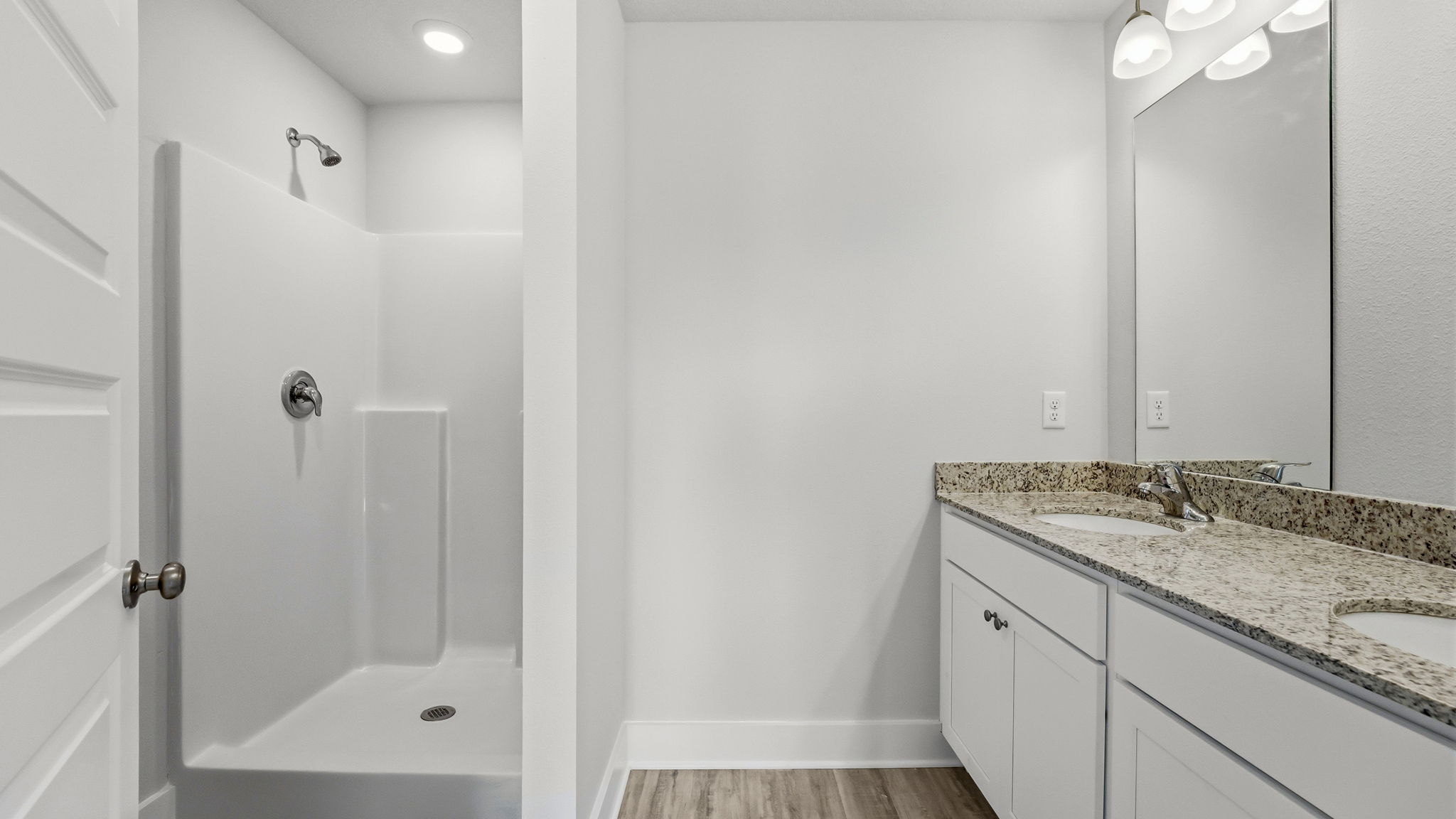 Bathroom with granite countertops and double vanity and shower.