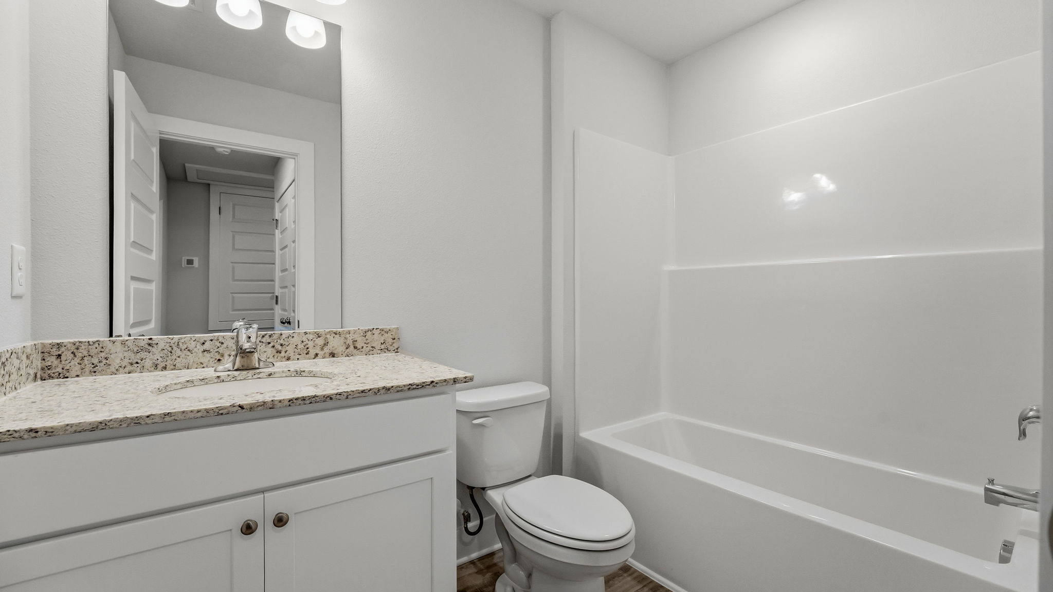 Bathroom with granite countertops and single vanity and shower and tub and toilet.