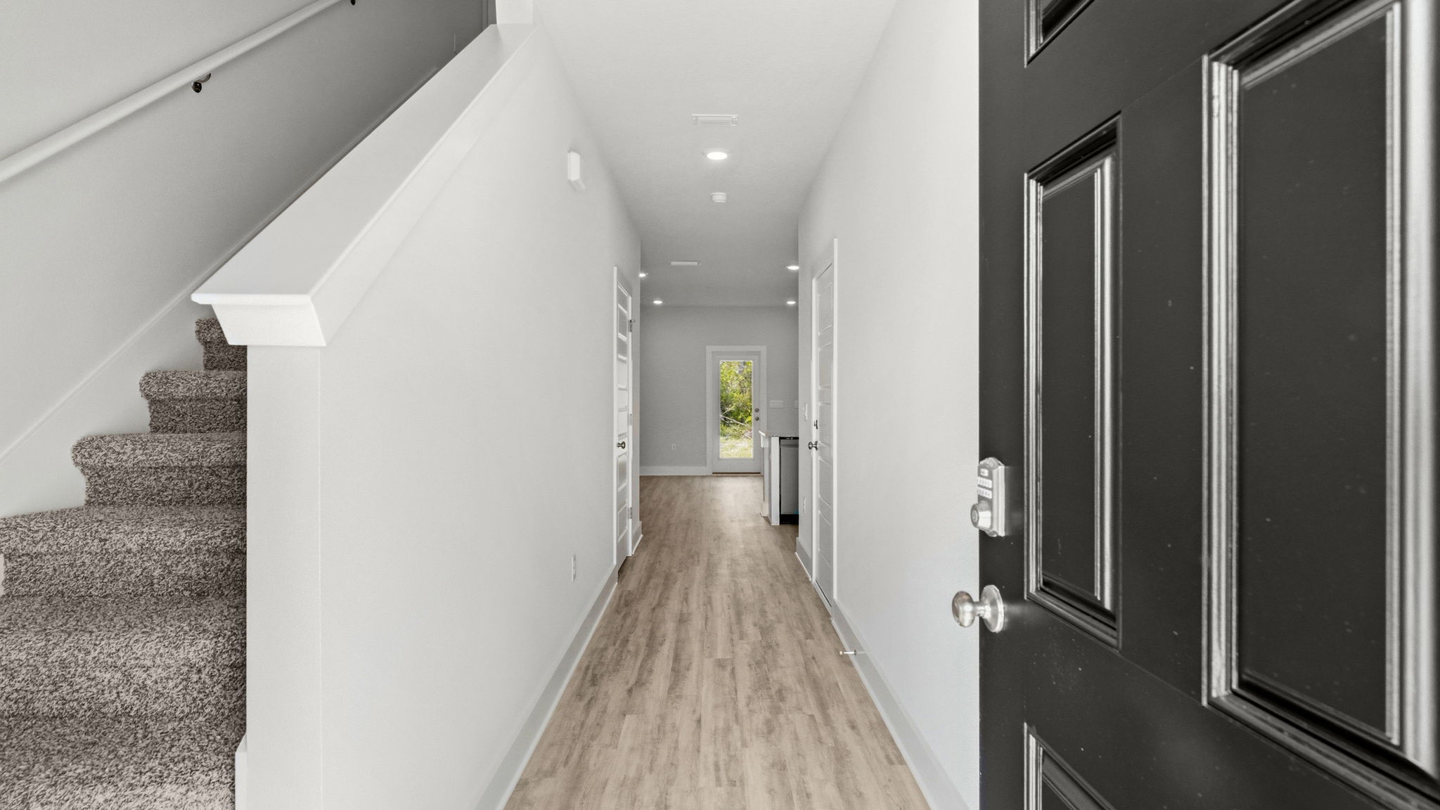 Front entrance hallway with EVP flooring next to carpeted stairs.
