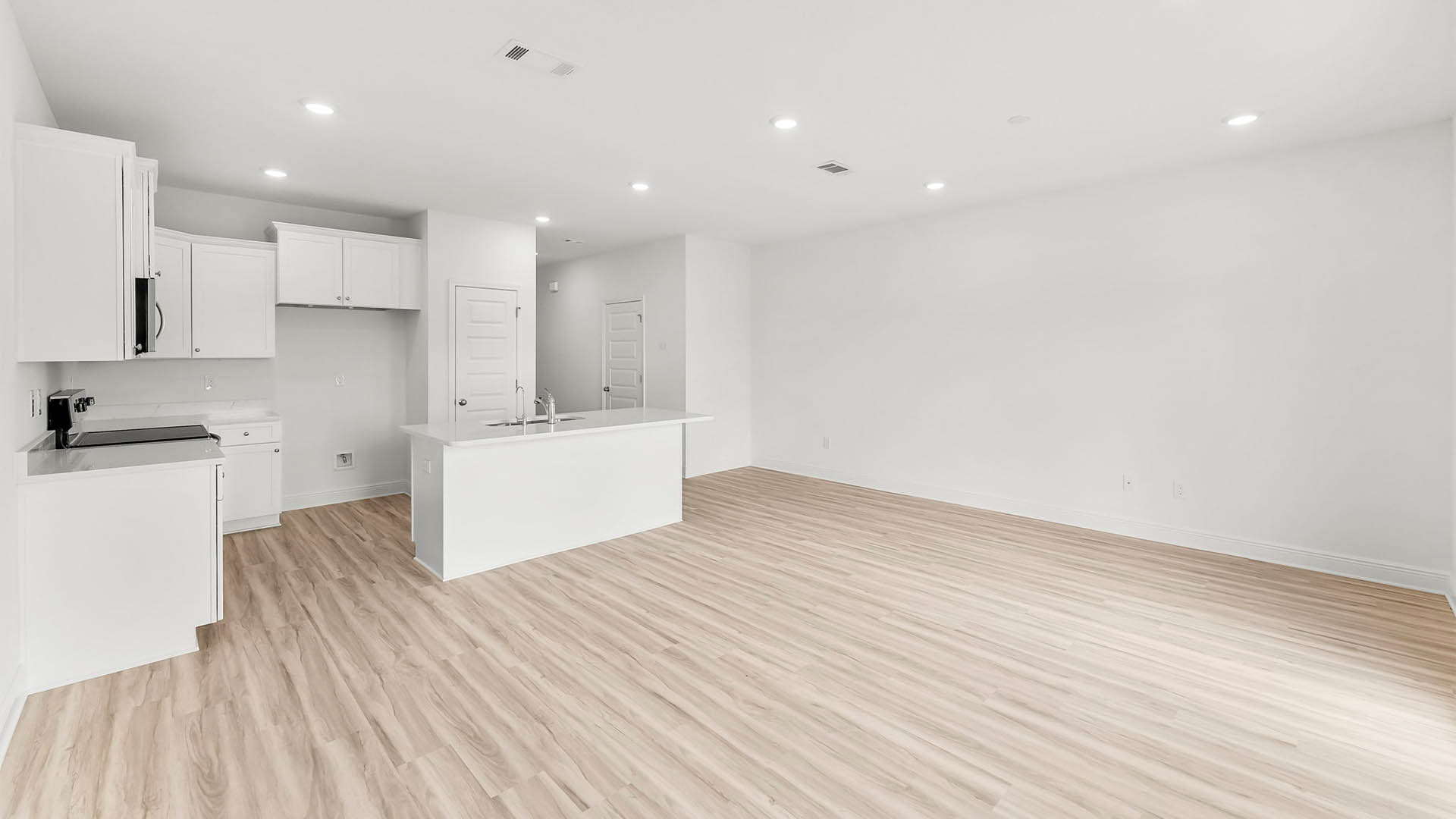 Open living room with EVP flooring and kitchen.