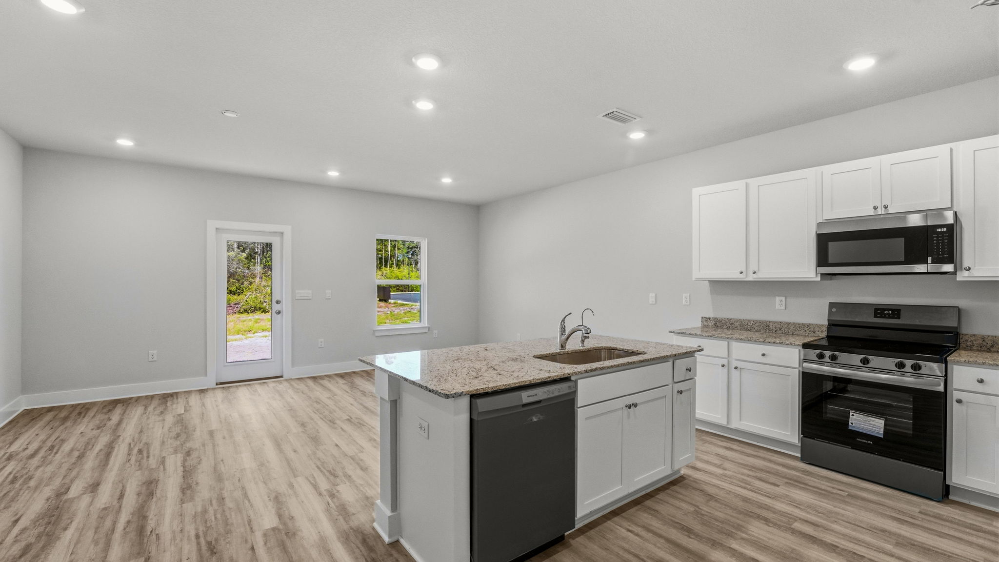 Open living room with EVP flooring and kitchen.