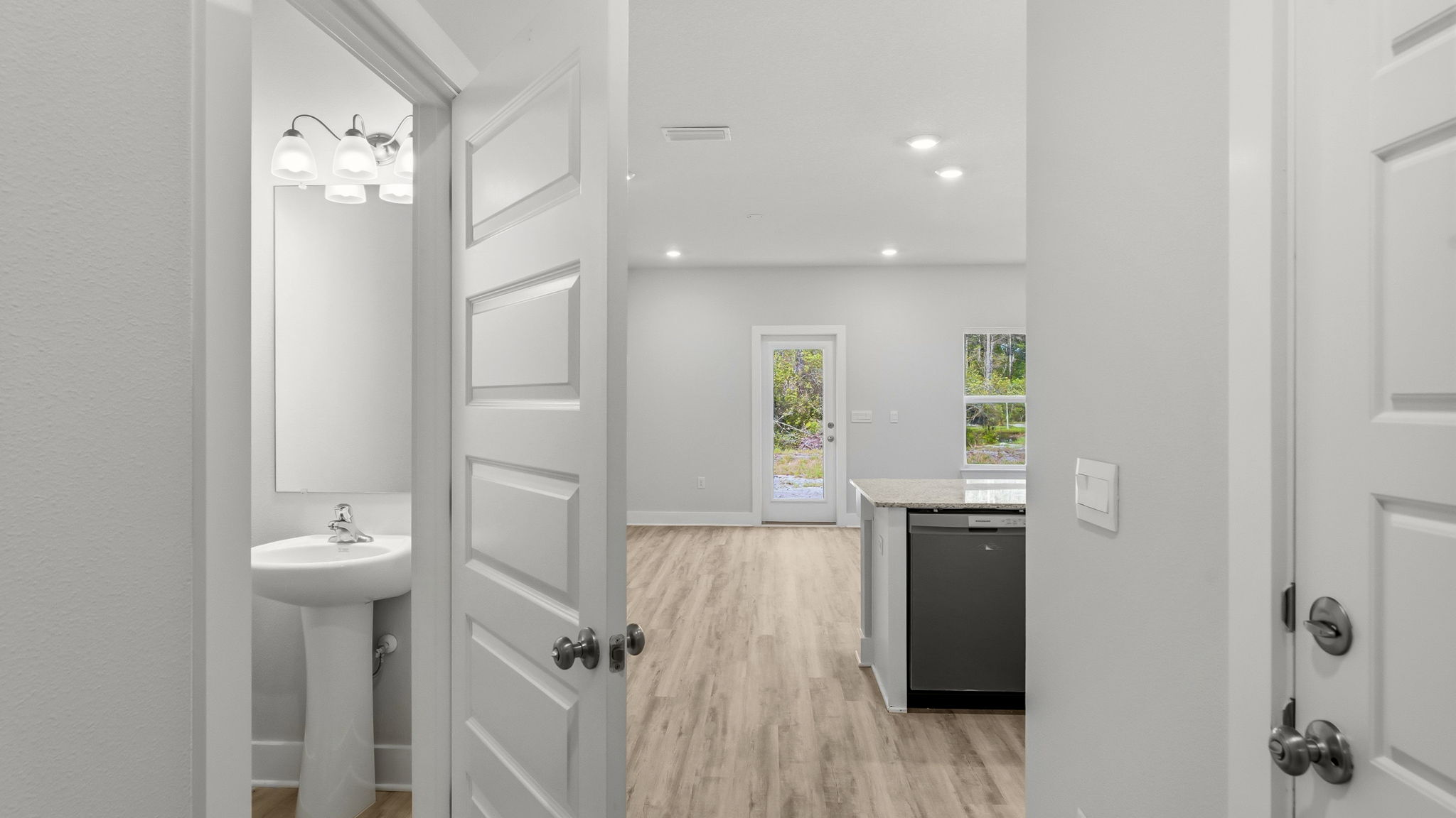 Front entrance hallway next to half bathroom and garage leading to main living area.